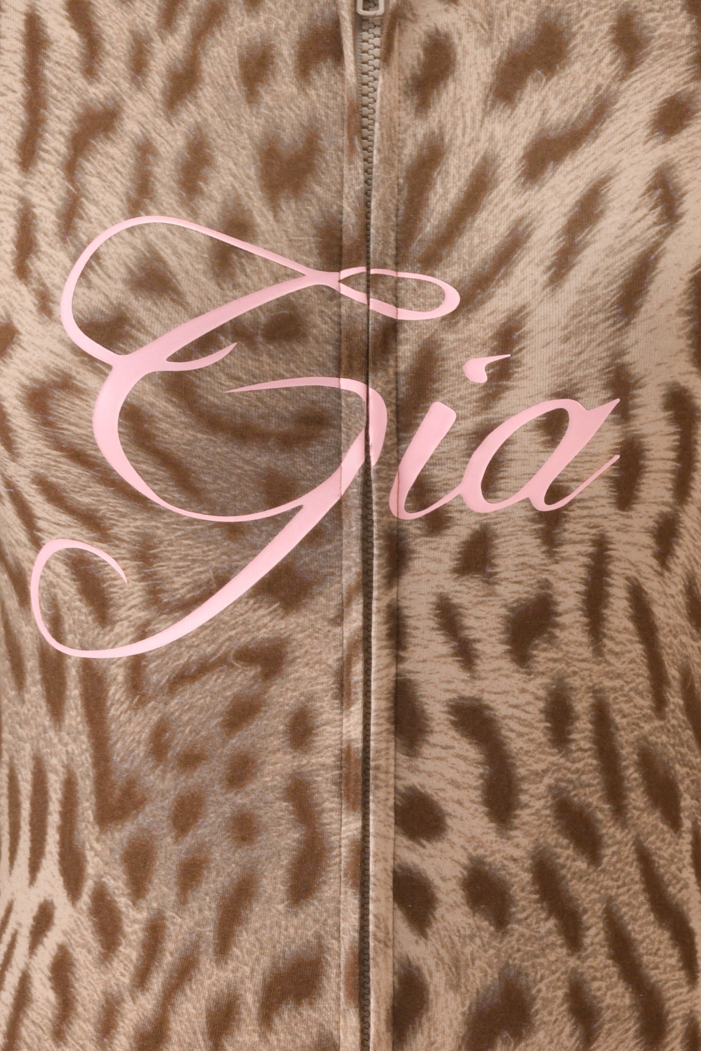Close-up of the BLARE HOODIE - BLAZE CHEETAH by I.AM.GIA features cheetah print bamboo viscose, a vertical zipper, and "Gia" in bold pink script across the center.