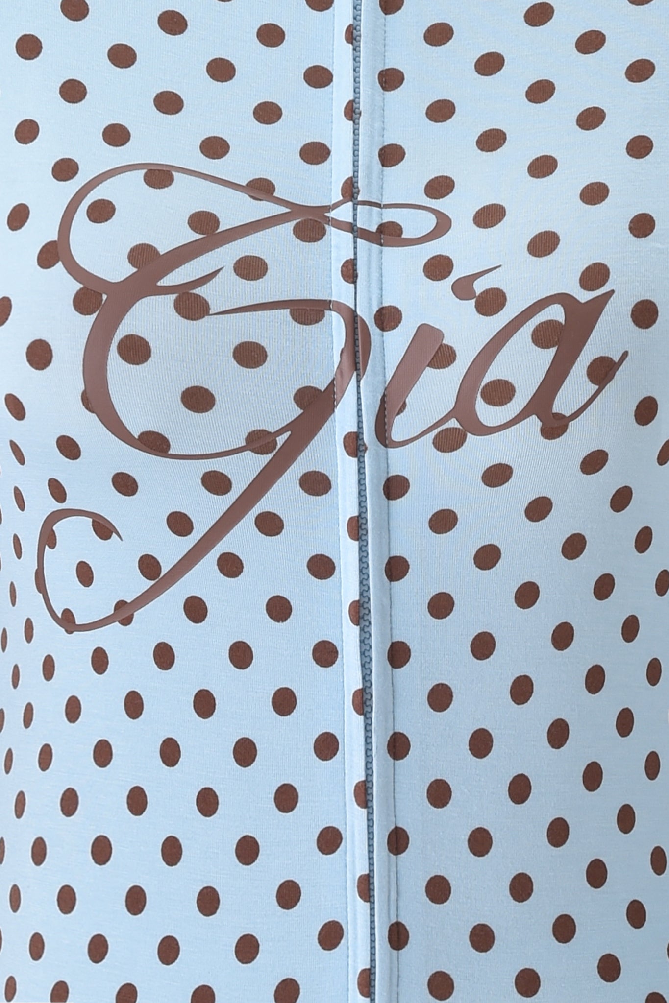Close-up of the BLARE HOODIE - BLUE POLKA DOT by I.AM.GIA, showcasing bamboo fabric with brown polka dots on light blue and "Gia" in bold cursive—ideal for a stylish look.