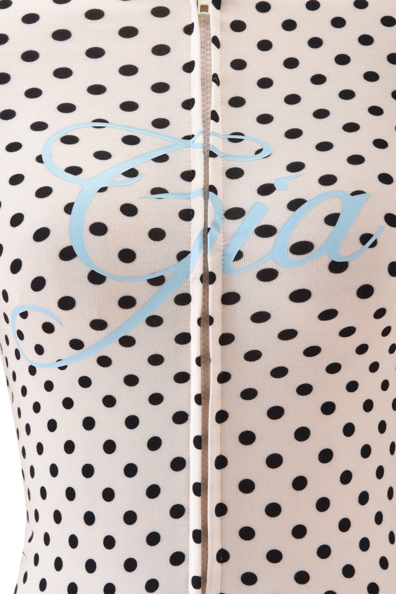 Close-up of the BLARE HOODIE - CREAM POLKA DOT by I.AM.GIA, a viscose jersey hoodie with black polka dots and "Gia" in large light blue script across the front.