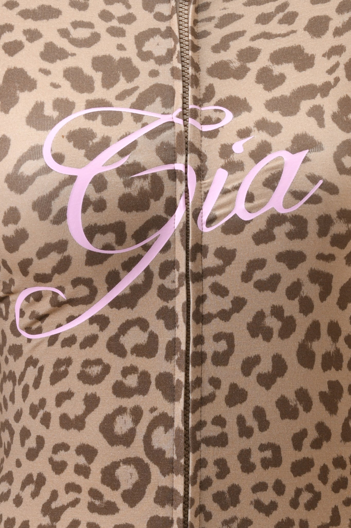 Close-up of mocha leopard print fabric with "Gia" in large, light pink cursive across the center. A vertical seam hints at a luxe bamboo BLARE HOODIE - MOCHA LEOPARD by I.AM.GIA.