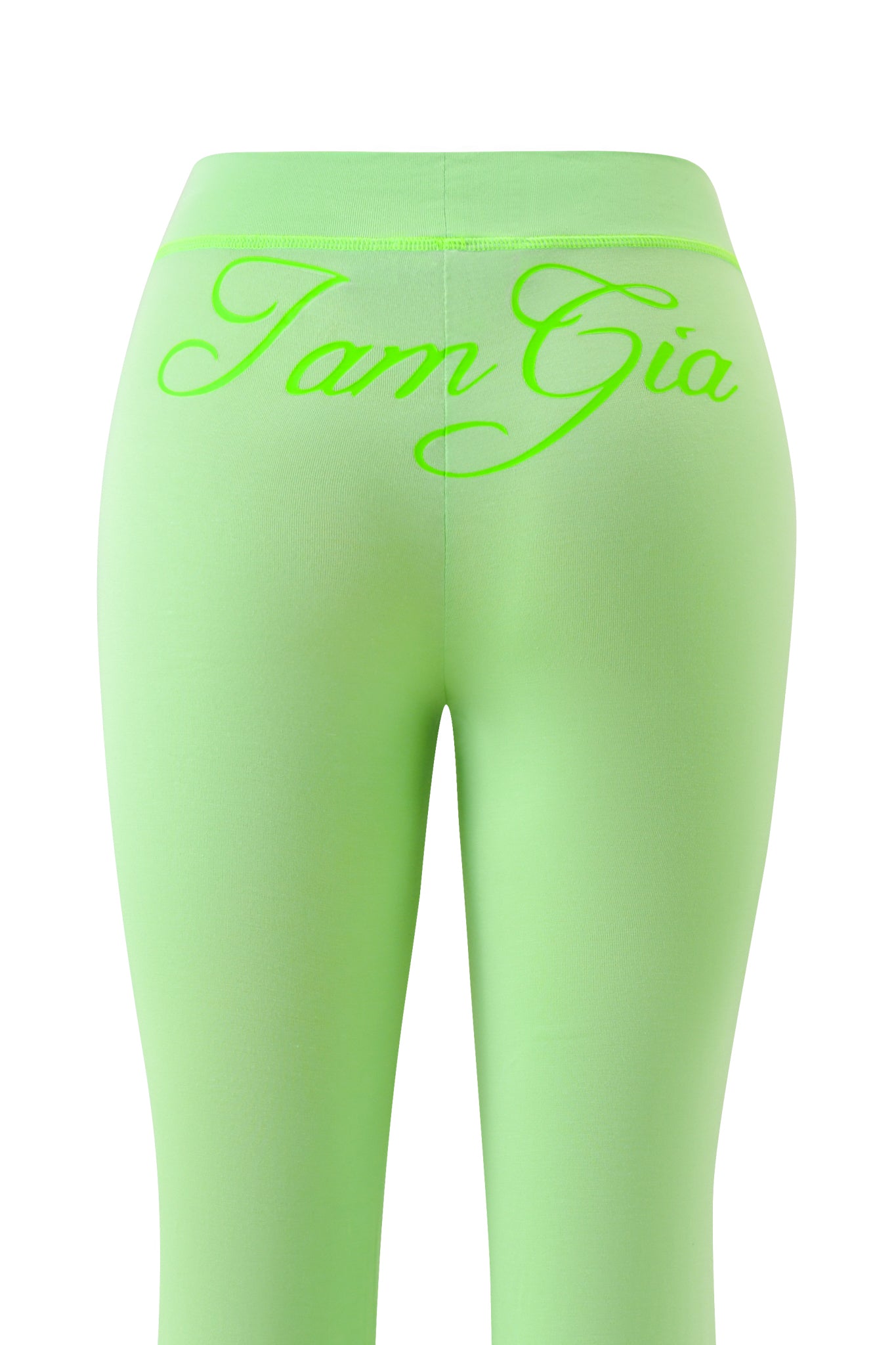 The BLARE TRACKPANT - NEON GREEN by I.AM.GIA features low-rise, lime green leggings with "I am Gia" in bold neon script across the back waistband, shown on a white background.