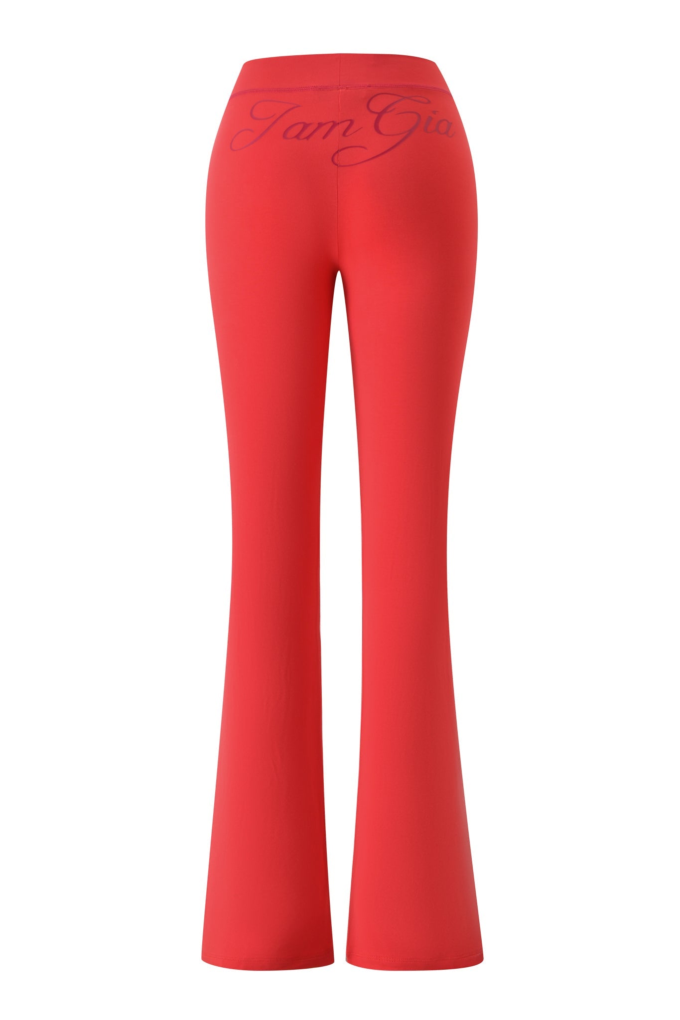 The BLARE TRACKPANT - PAPAYA by I.AM.GIA is a bright red, mid-rise pant with flared legs, seen from the back and featuring bold, cursive "IamGia" lettering across the waistband.