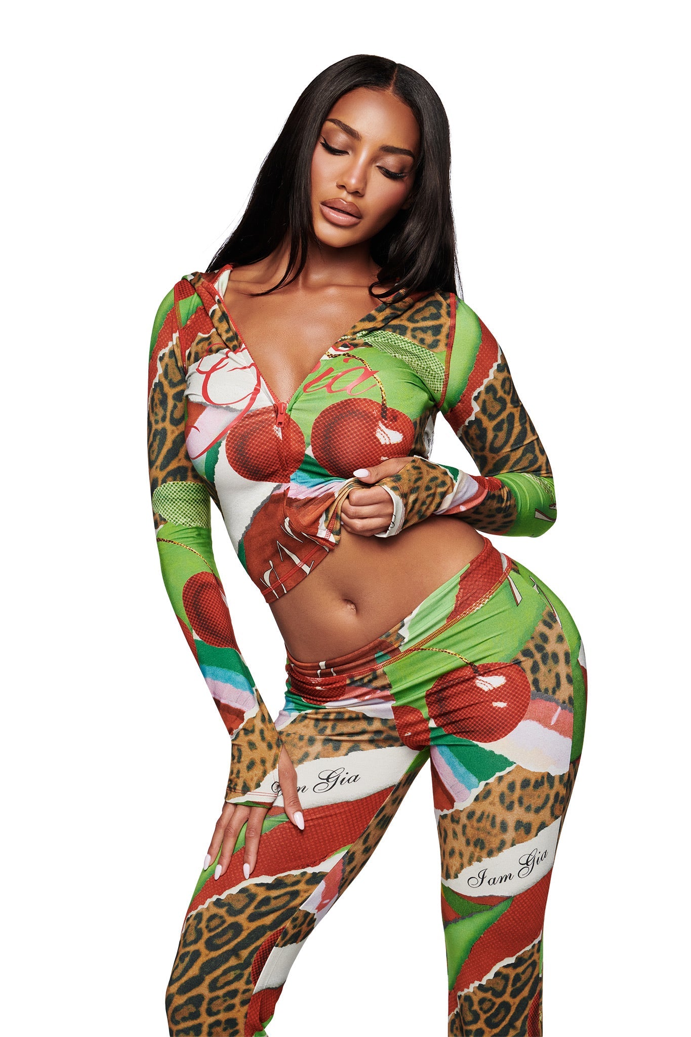 A woman models the I.AM.GIA BLARE HOODIE in the bold Wild Cherry print, featuring a vibrant tropical and leopard design with a front zipper and long sleeves for a daring statement look.