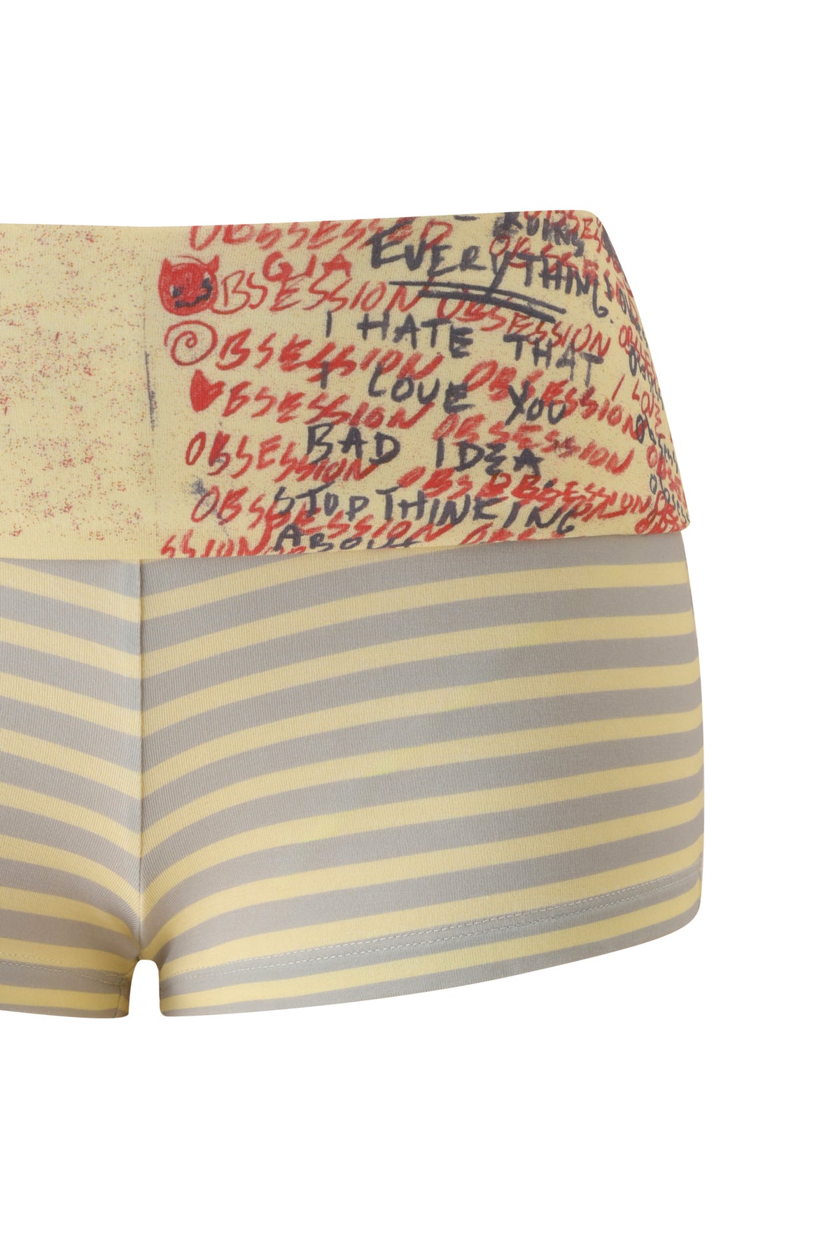 The T-REX BLARE 2.0 SHORT - YELLOW by I.AM.GIA features a high-waisted, bodycon fit with horizontal yellow and gray stripes. The beige foldover waistband is adorned with red and black handwritten text—including repeated words like "obsession"—and a small red cat drawing.