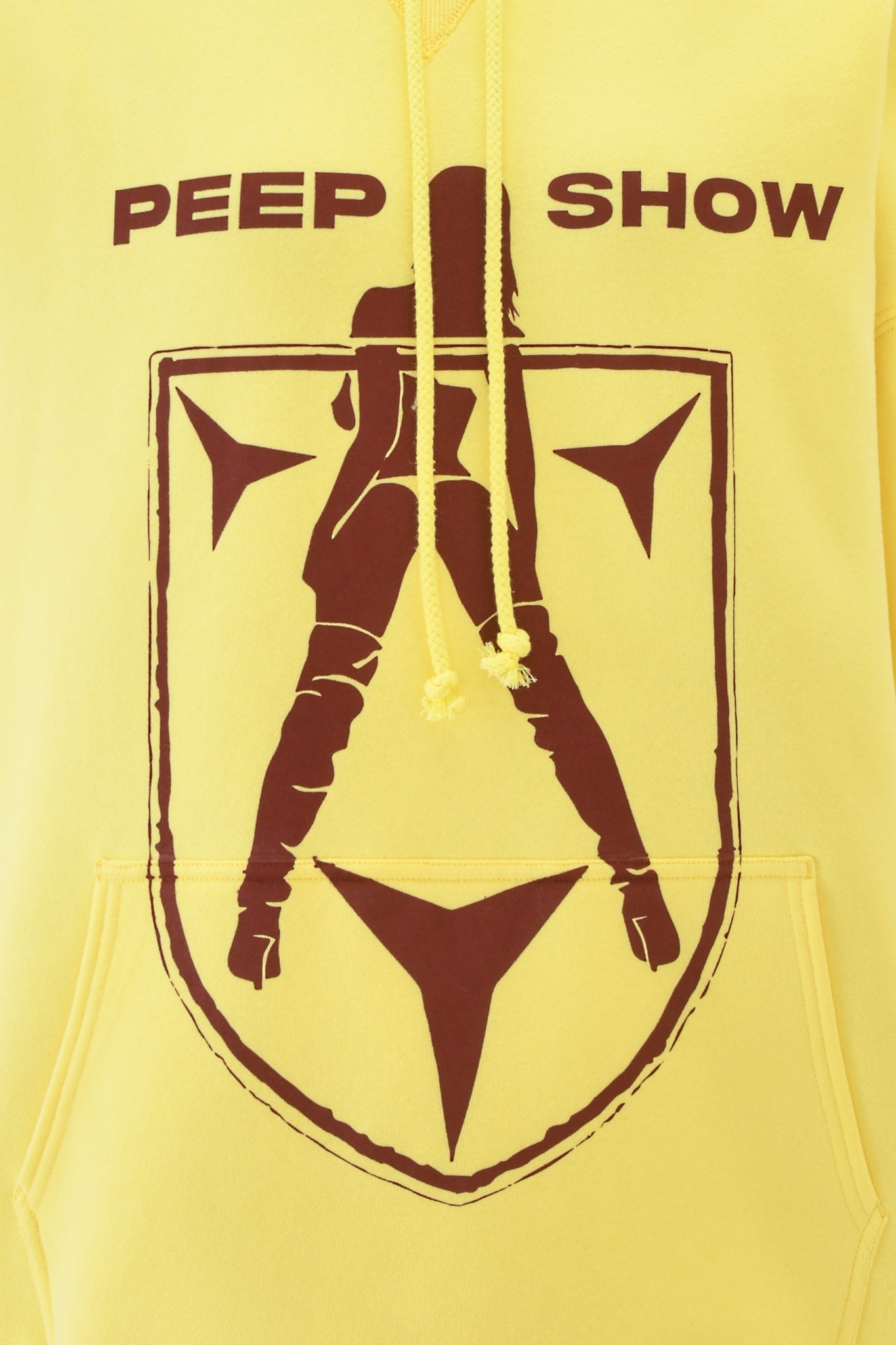 The DORIAN HOODIE - YELLOW by I.AM.GIA features an oversized silhouette of a woman in high boots inside a shield, with "PEEP SHOW" boldly printed above.