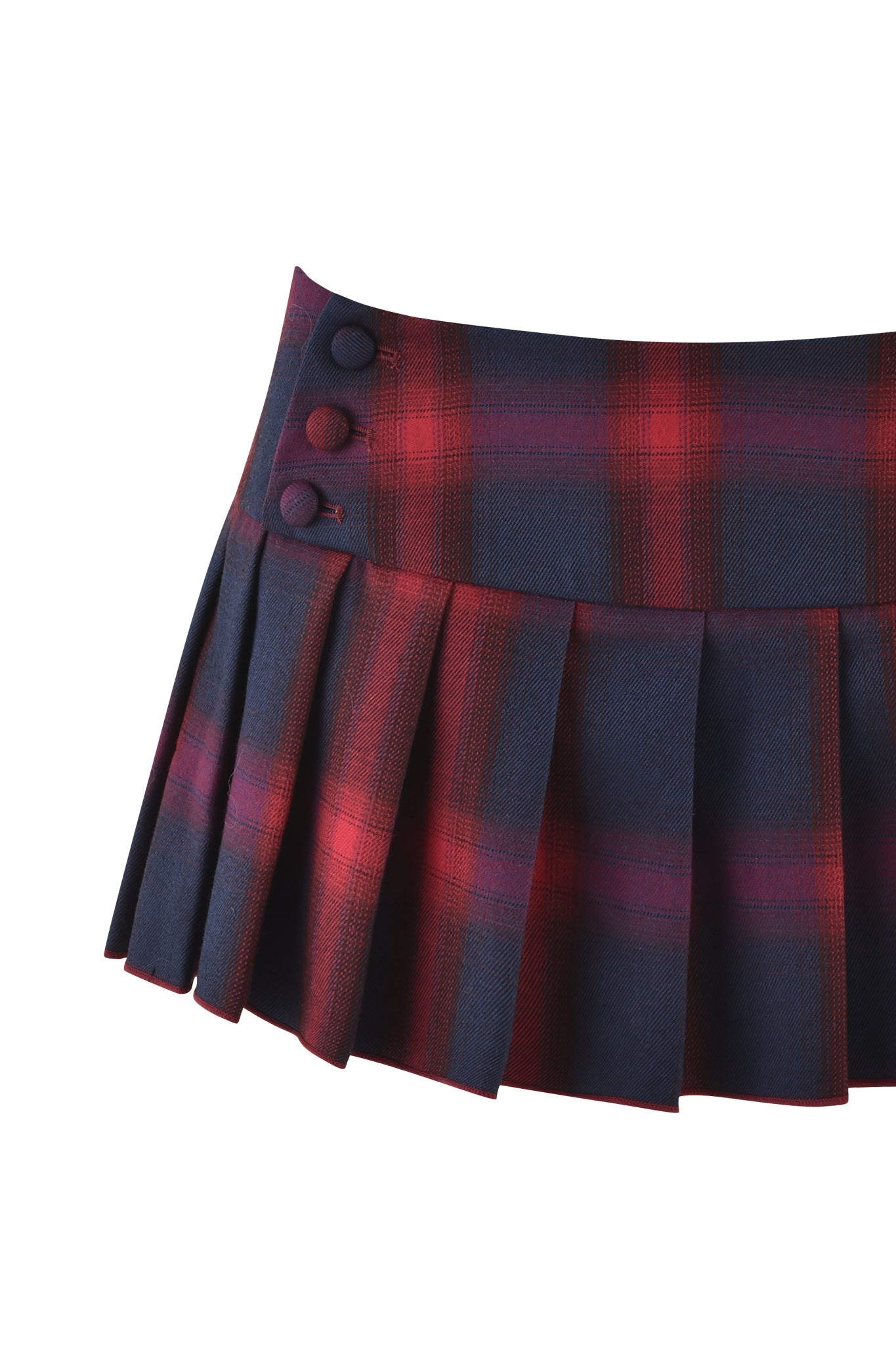 The REMINI MINI SKORT 3.0 by I.AM.GIA is a red and dark blue plaid skort made with premium fabric, featuring pleats and three round buttons on its low-rise waistband, set against a white background.