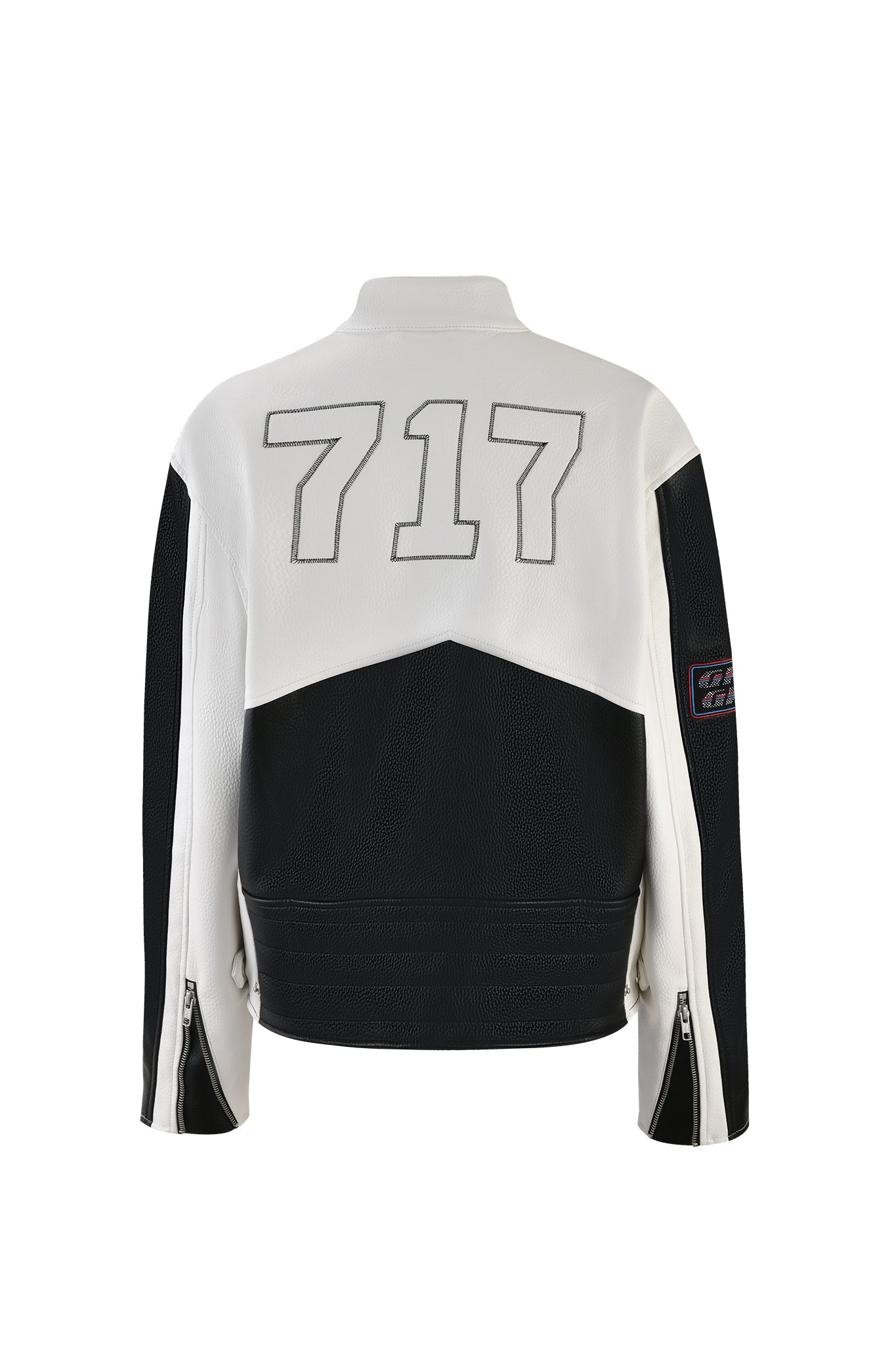 A stylish I.AM.GIA ROXY JACKET - WHITE with a black and white color scheme, seen from the back. The upper portion and sleeves are white, featuring the number "717" in light gray. The lower portion is black with zippered sleeve cuffs. A small patch with text is visible on the right sleeve.