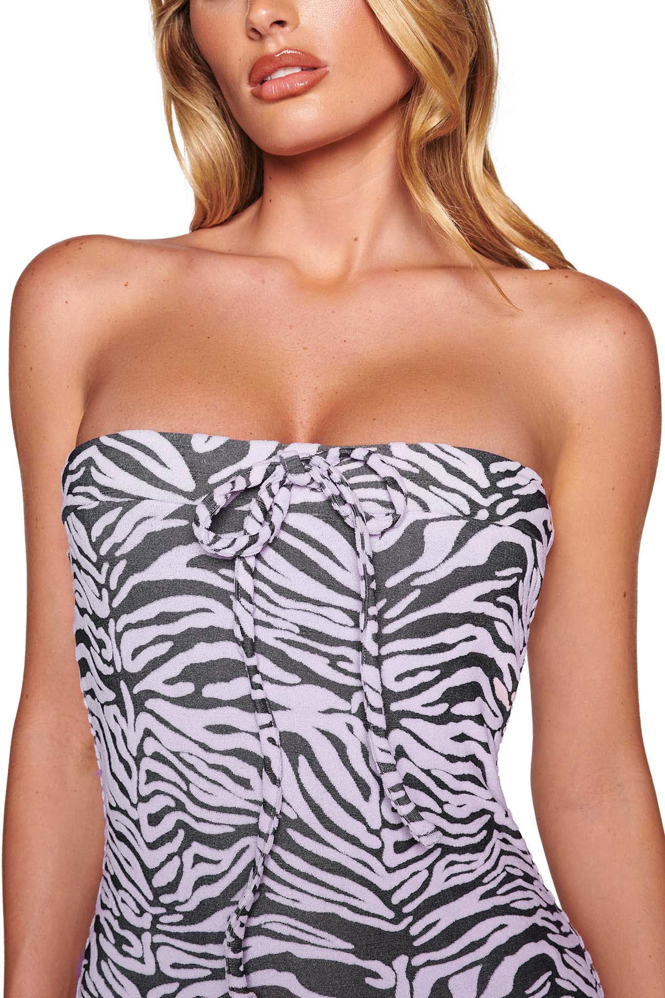 A woman with long blond hair is wearing a pink zebra print Narella dress by I.AM.GIA. The strapless, bodycon fit dress features a knotted detail in the center at the top. The background is white.