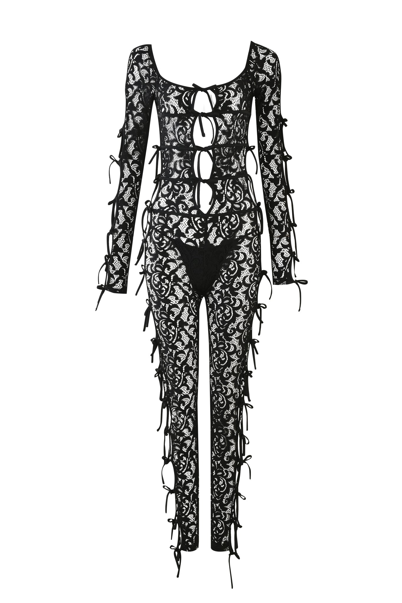 Introducing the LYSANDRA CATSUIT - BLACK by I.AM.GIA: a stunning black lace jumpsuit featuring long sleeves and a sleek, fitted design. This garment showcases multiple openings down the front, beautifully adorned with bow ties, and an intricate floral lace pattern throughout. The legs are enhanced with matching cut-out sections tied with bows for an elegant finish.