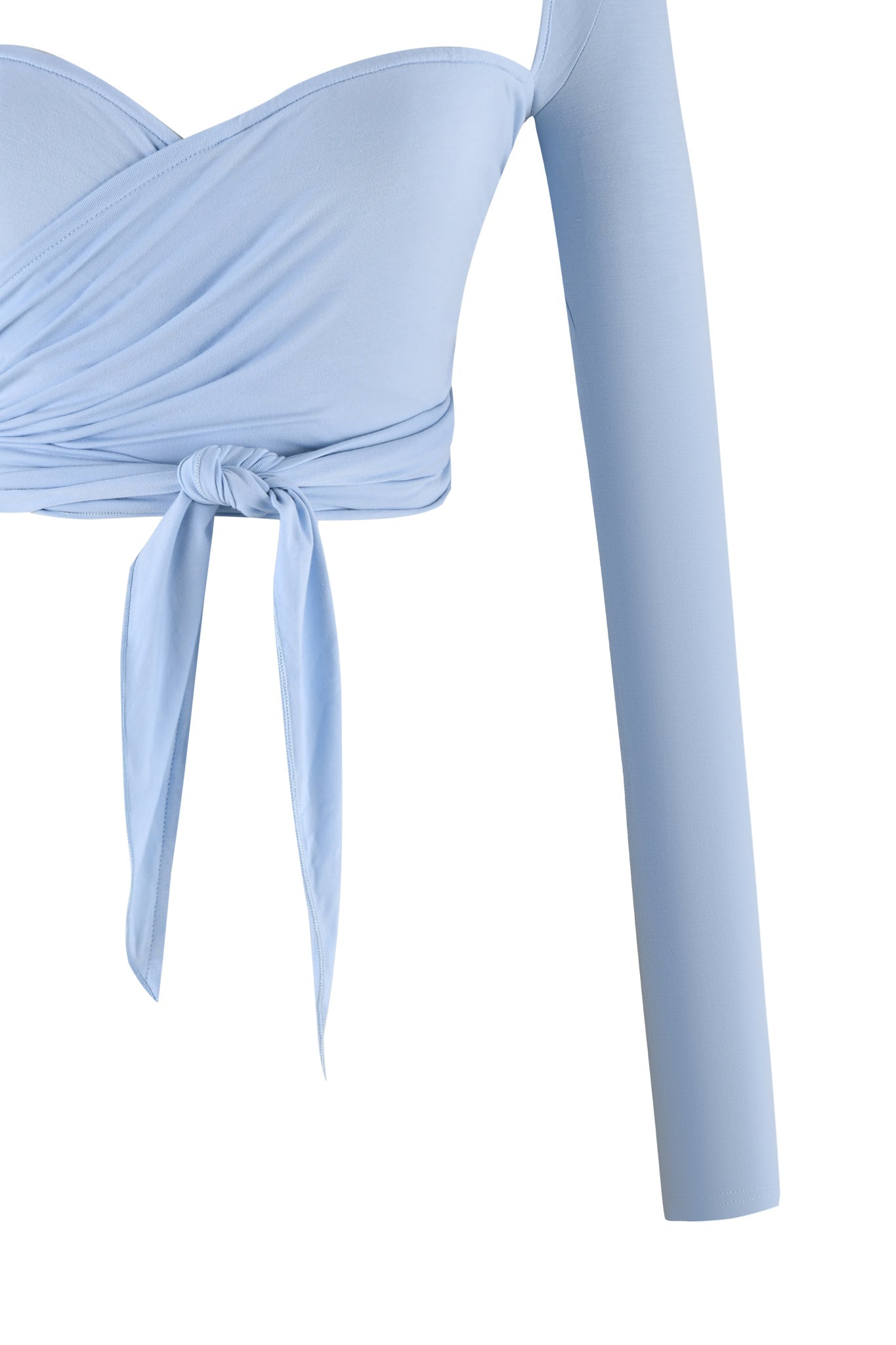 The AMRIA TOP - BLUE from I.AM.GIA, in a stunning powder blue shade, features an off-the-shoulder design and long sleeves. This bodycon fit crop top is adorned with a front tie knot that creates elegant pleats around the chest area. Notably, the image only shows one sleeve, showcasing its chic asymmetrical style.