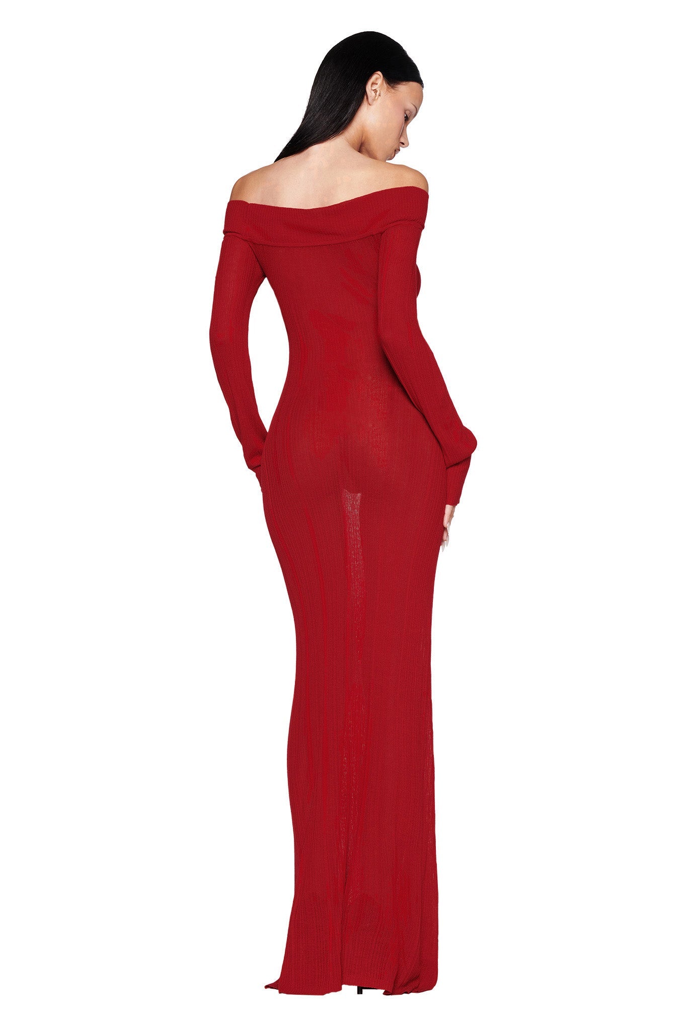 Someone in an ANASTASIA MAXI DRESS - RED : BURGUNDY by I.AM.GIA is standing with their back to the camera. The off-the-shoulder style enhances the form-fitting design that flows elegantly to the floor. Their dark hair cascades down against a plain white background, beautifully showcasing the knit fabrication of the dress.