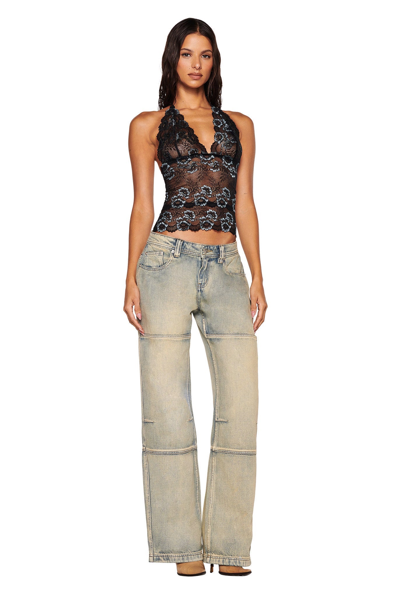 A woman with long dark hair faces forward in a black lace halter top and I.AM.GIA MISTY JEAN - TAN 2.0 light-wash wide-leg jeans with visible seams, posing against a white background.