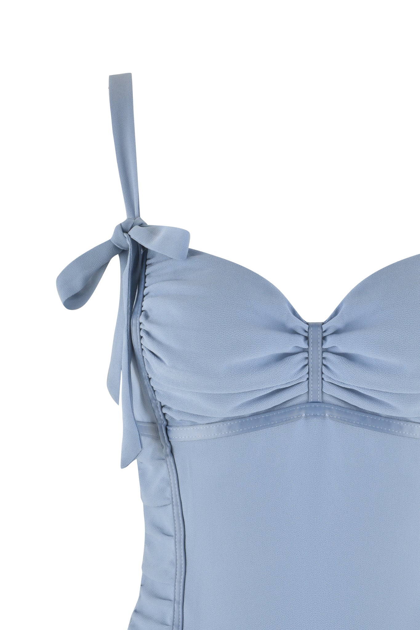 Close-up of the QUEENIE TOP - BLUE from I.AM.GIA, featuring ruched paneling on the bodice and spaghetti straps tied into bows at the shoulders. The STEEL BLUE material appears soft and smooth, highlighting the elegant and feminine design reminiscent of a bustier top.