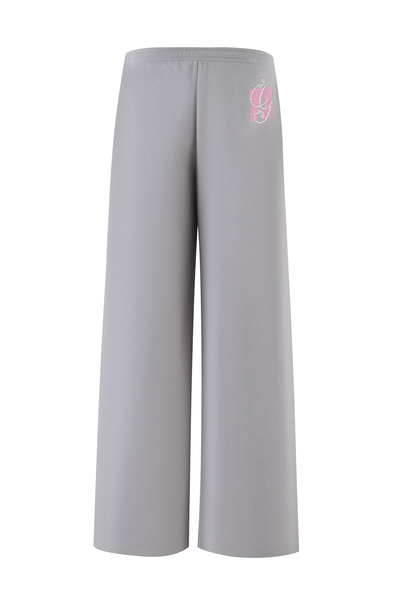 The ARLO TRACK PANT - GREY : PINK by I.AM.GIA features wide-leg track pants with an elastic waistband and a pink cursive "G" logo on the upper left thigh.