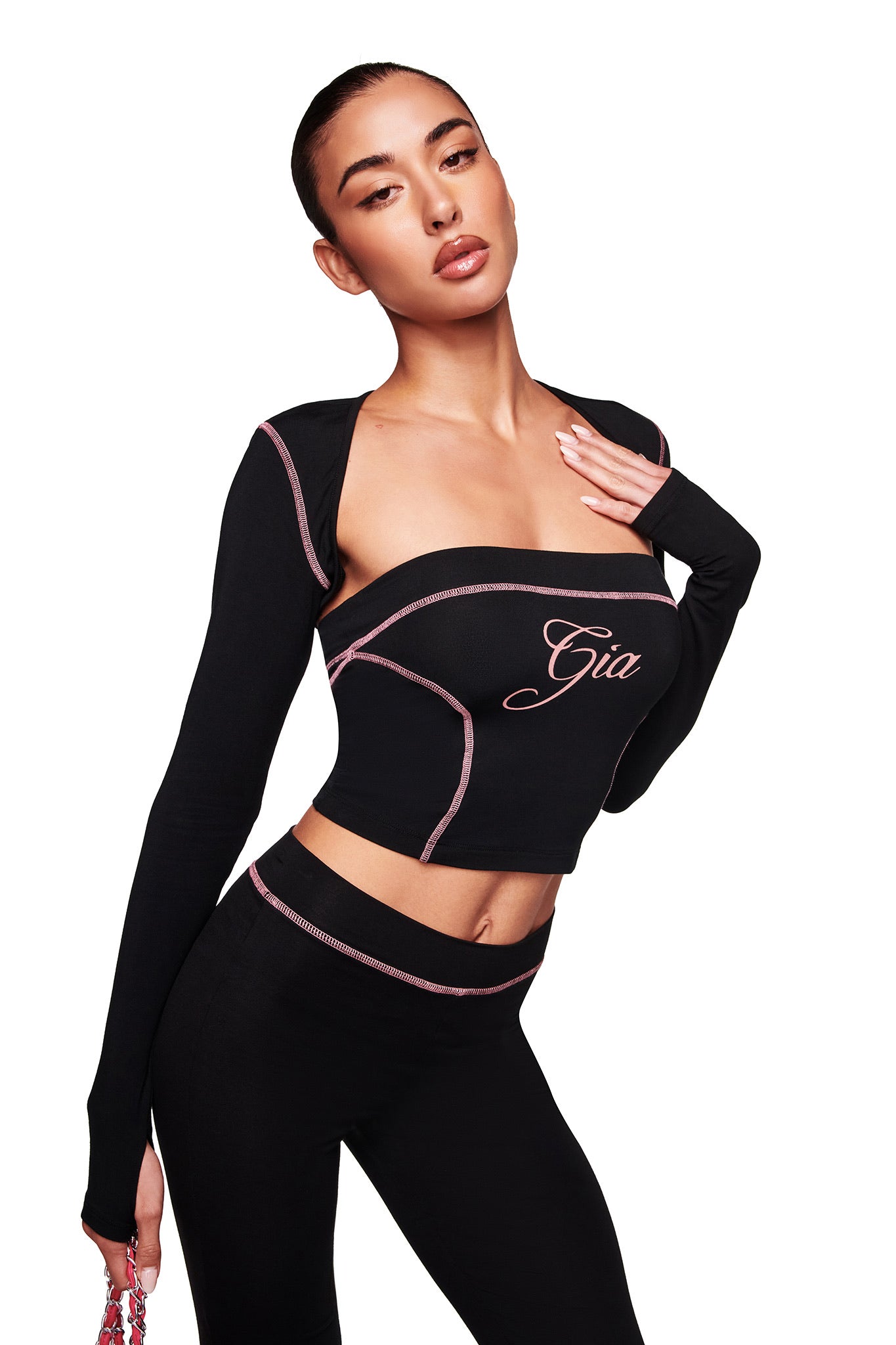 A woman poses in the BLARE BOOB TUBE - BLACK by I.AM.GIA, a black strapless crop top, paired with matching high-waisted pants against a white background.
