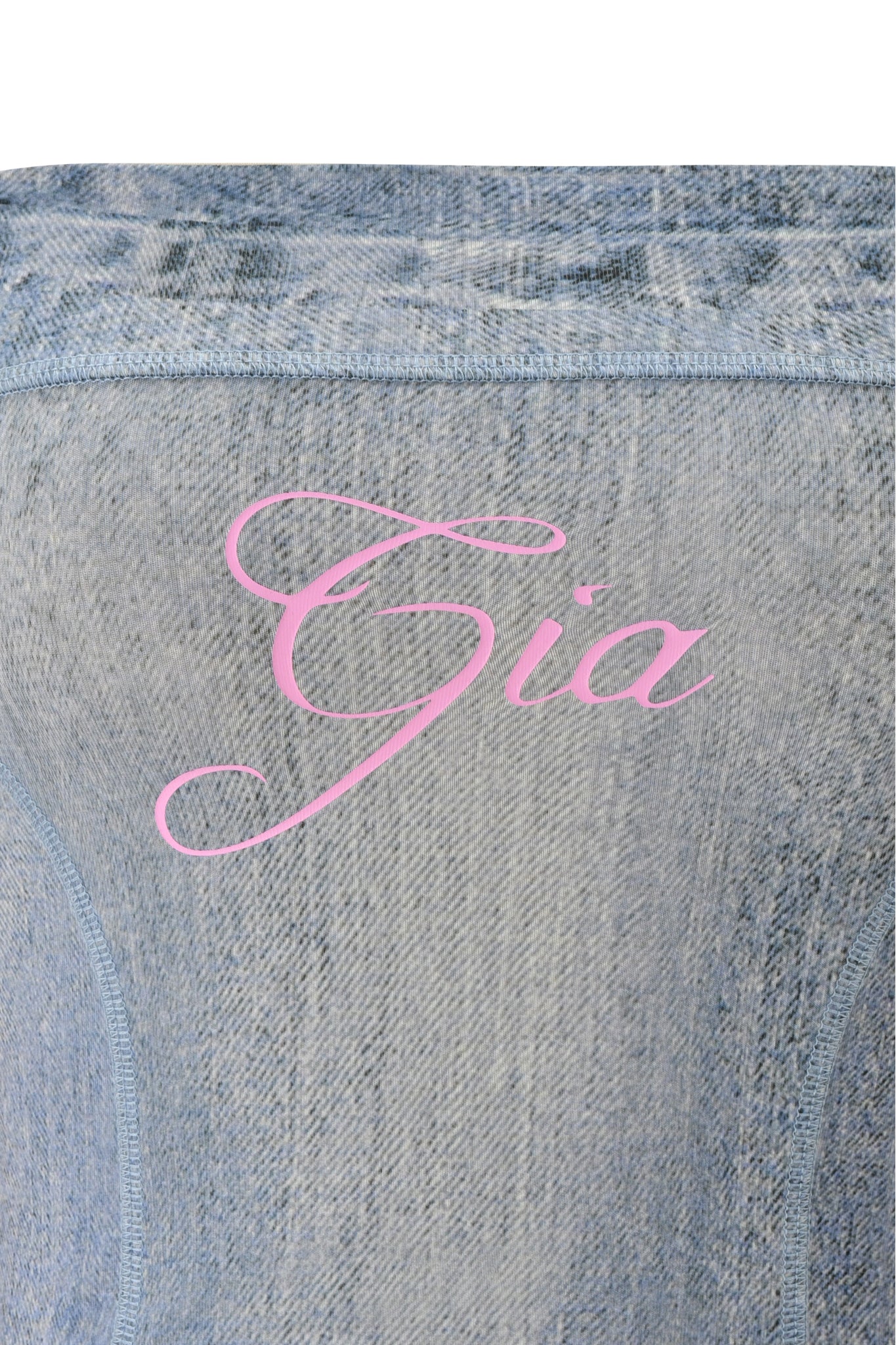 The BLARE BOOB TUBE - DENIM TROMPE L'OEIL by I.AM.GIA features light blue denim in a chic bodycon crop top style with “Gia” in elegant pink cursive across the center.
