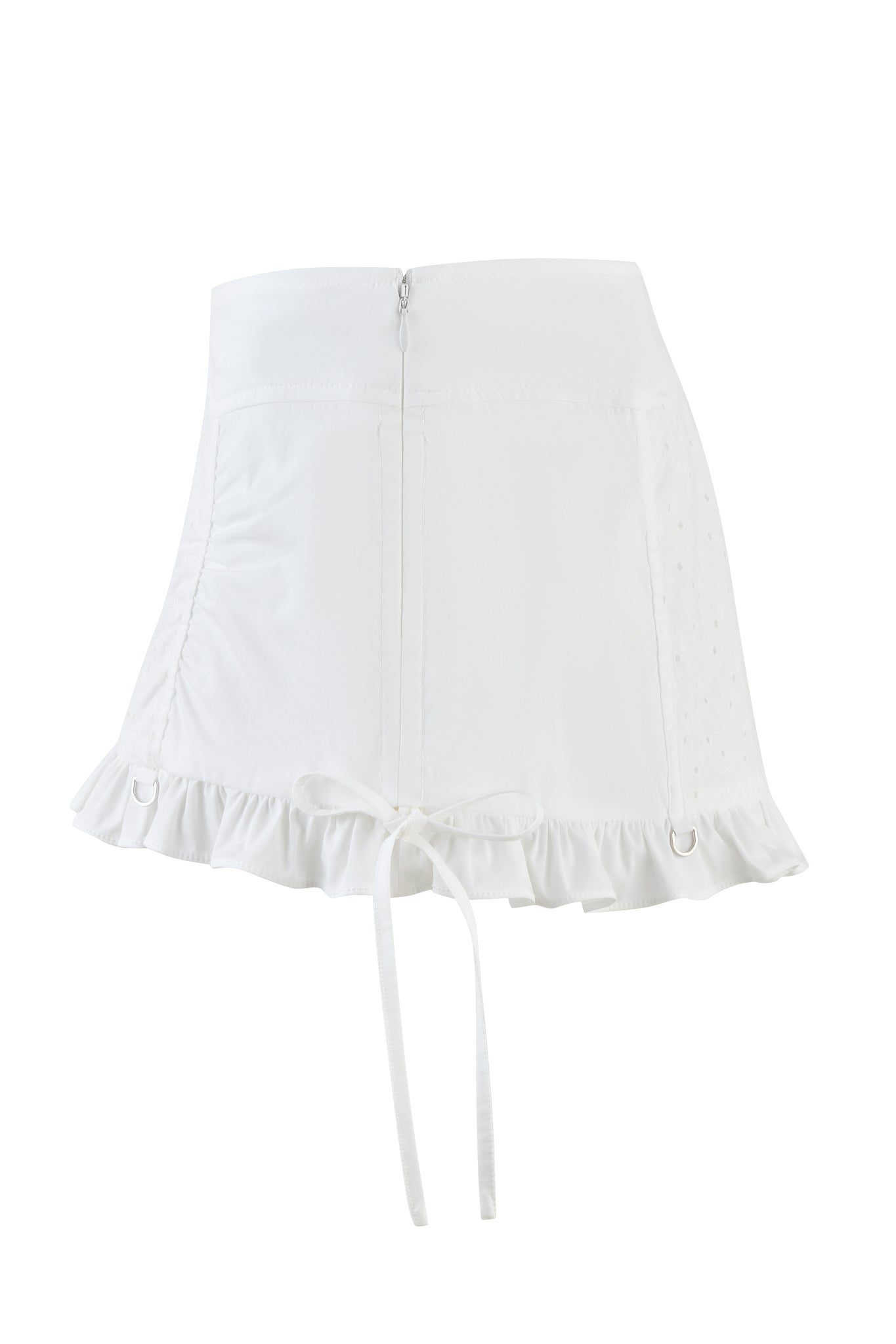 The WREN MINI SKIRT by I.AM.GIA is a high-waisted, white eyelet mini skirt with a front zipper, ruffled hem, and subtle dot patterns on the sides. It features ribbon ties that hang gracefully in the front.