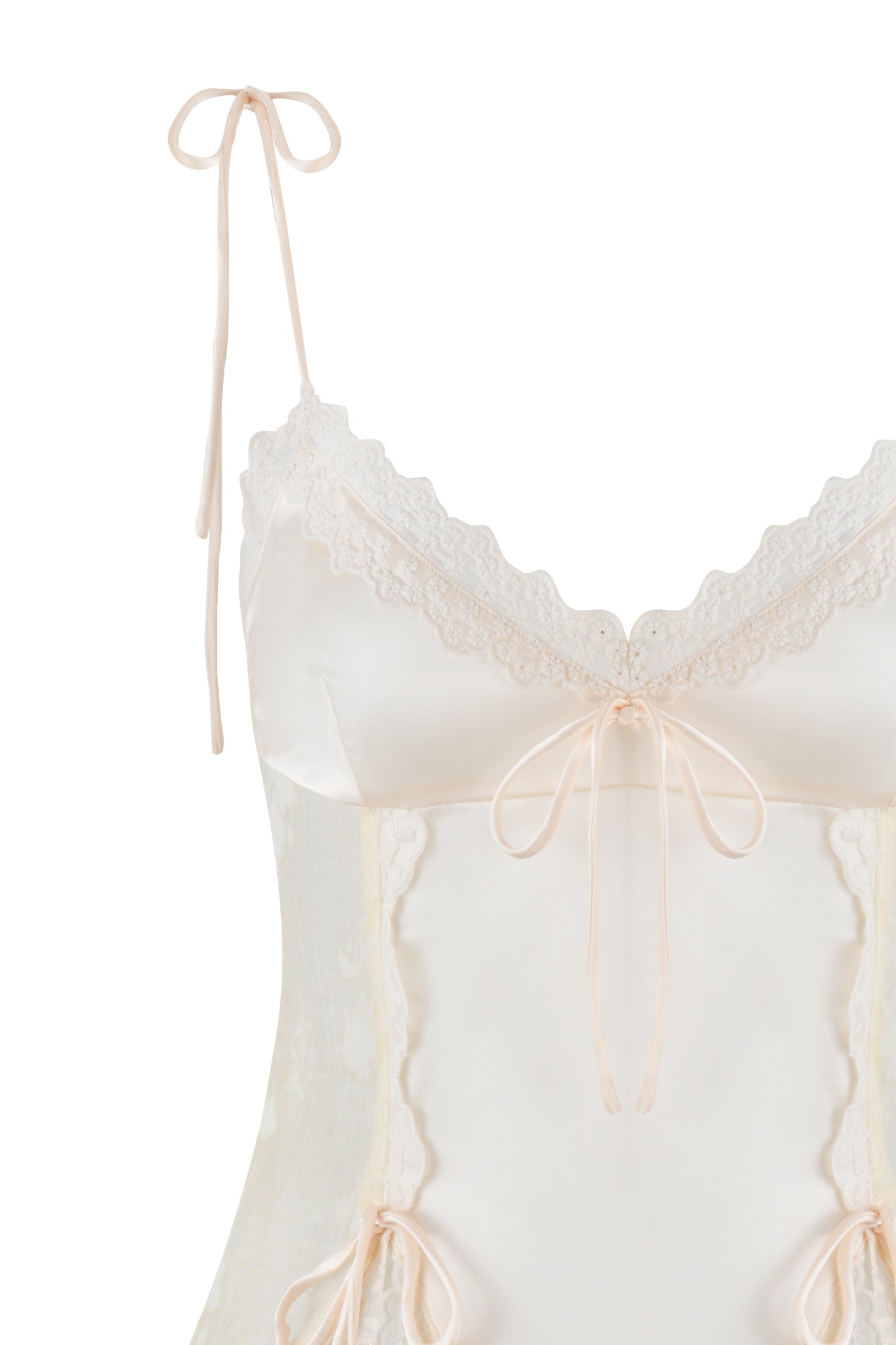 The MEADOW TOP - WHITE: FLORAL DELIGHT by I.AM.GIA features a delicate and stylish design, crafted from stretch satin with intricate lace trims on the bodice and thin shoulder straps tied in bows, finished with an elegant ribbon at the center.