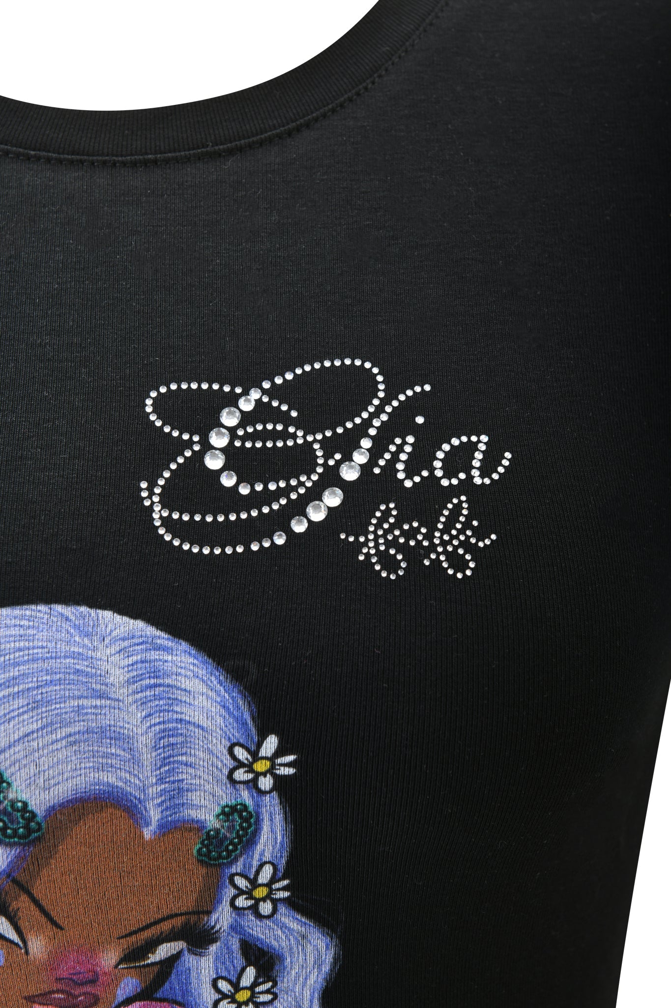 Close-up of the FAFI T-SHIRT - BLACK by I.AM.GIA, featuring a woman with light purple hair and daisies. "Diva" in diamanté accents and a decorative underline complete this bold baby tee look.