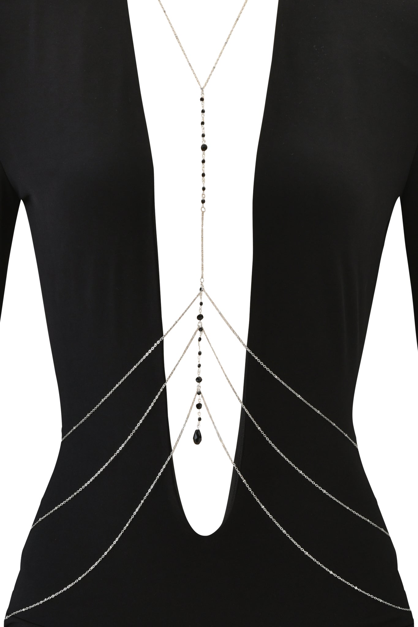 A person styled in the I.AM.GIA PADMA MINI DRESS - BLACK, a bodycon fit long sleeve mini dress with a deep V-neck, paired with a detachable body chain featuring black bead accents along the center and waist.