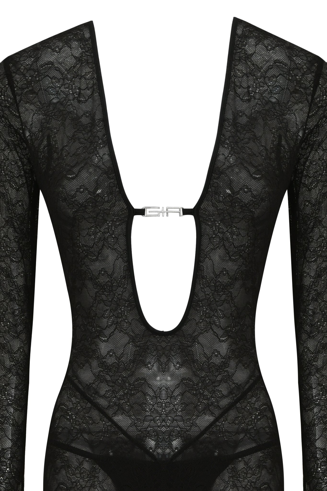 The TIGRA CATSUIT - BLACK by I.AM.GIA is a sheer, form-fitting lace bodysuit with long sleeves, a deep plunging neckline, and a silver clasp at the center front for an elegant, striking look.