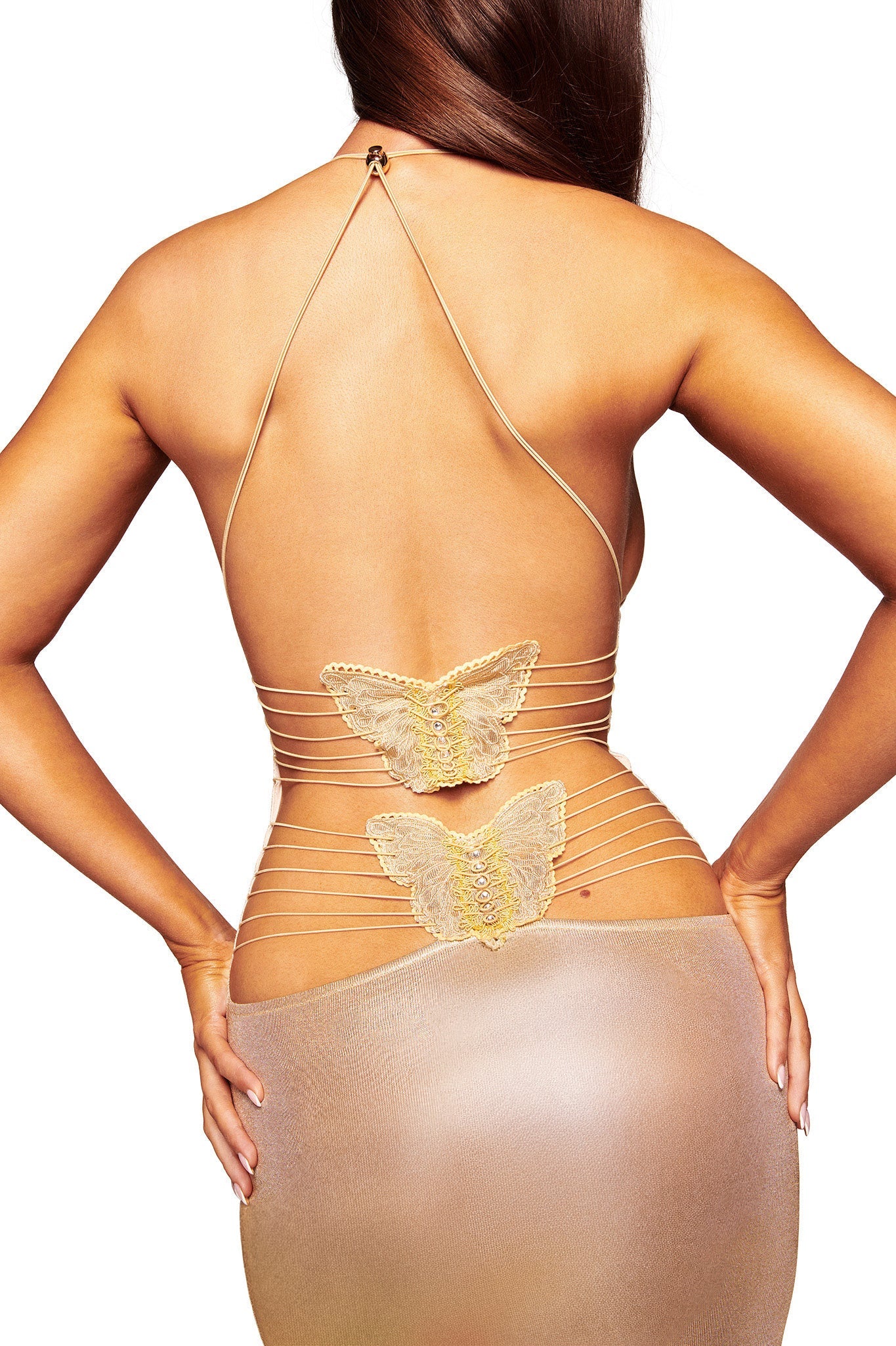 A woman poses with her back to the camera, wearing the I.AM.GIA ELLERY MAXI DRESS in gold, a light mesh maxi dress featuring thin straps and two butterfly-shaped embellishments across her lower back.