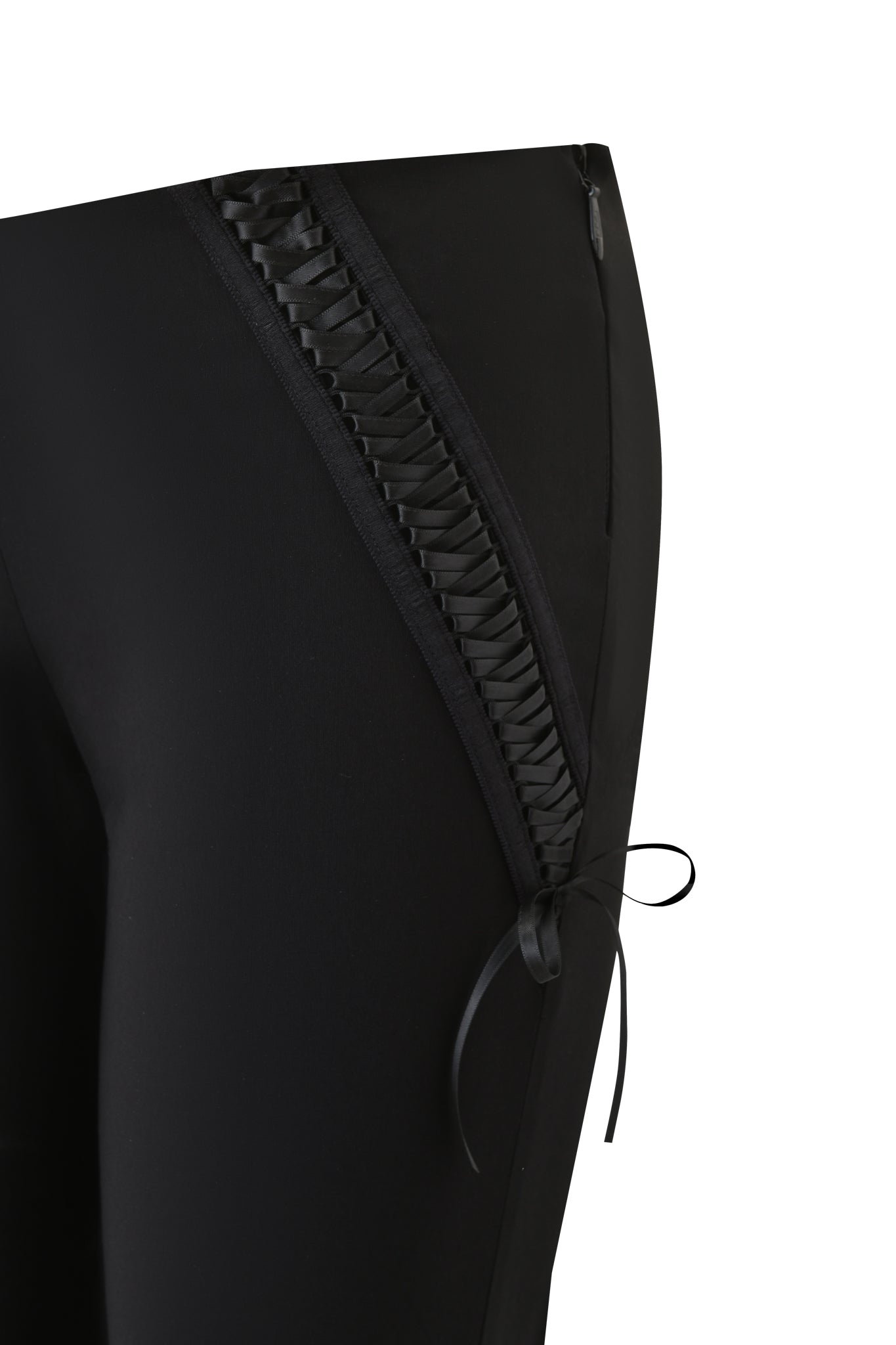 Close-up of the I.AM.GIA SAMIRA PANT - BLACK, featuring black flared legs, a low rise waist, and side panels with decorative ribbon lacing and a small bow near the hem, set against a white background.
