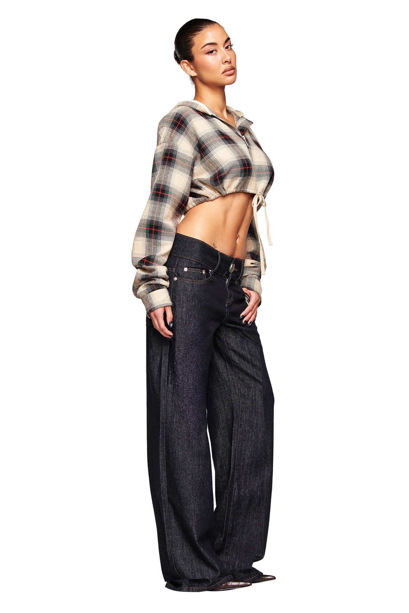 A woman wears the I.AM.GIA TIFF JACKET in grey plaid, styled cropped to show her midriff, paired with low-waisted wide-leg dark jeans and black shoes against a white background.