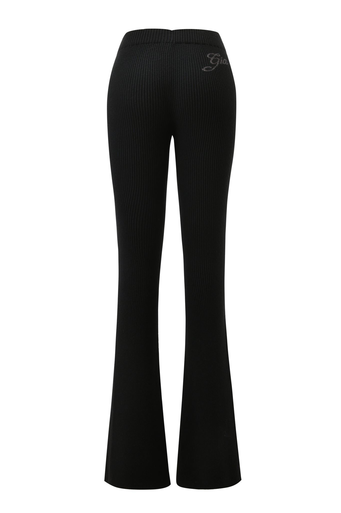 The BLARE KNIT TRACKPANT in black by I.AM.GIA features a ribbed knit texture, mid-rise elastic waistband, flare leg opening, and subtle right hip embroidery. Back view shown.