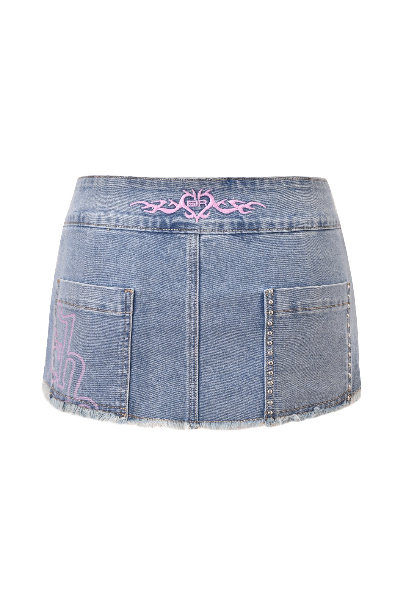 The I.AM.GIA X VON DUTCH SYNDRA DENIM MINI SKORT in light wash features a low rise, two back pockets with pink embroidery, silver studs on one pocket, raw hem, and a subtle pink pattern on the left side.