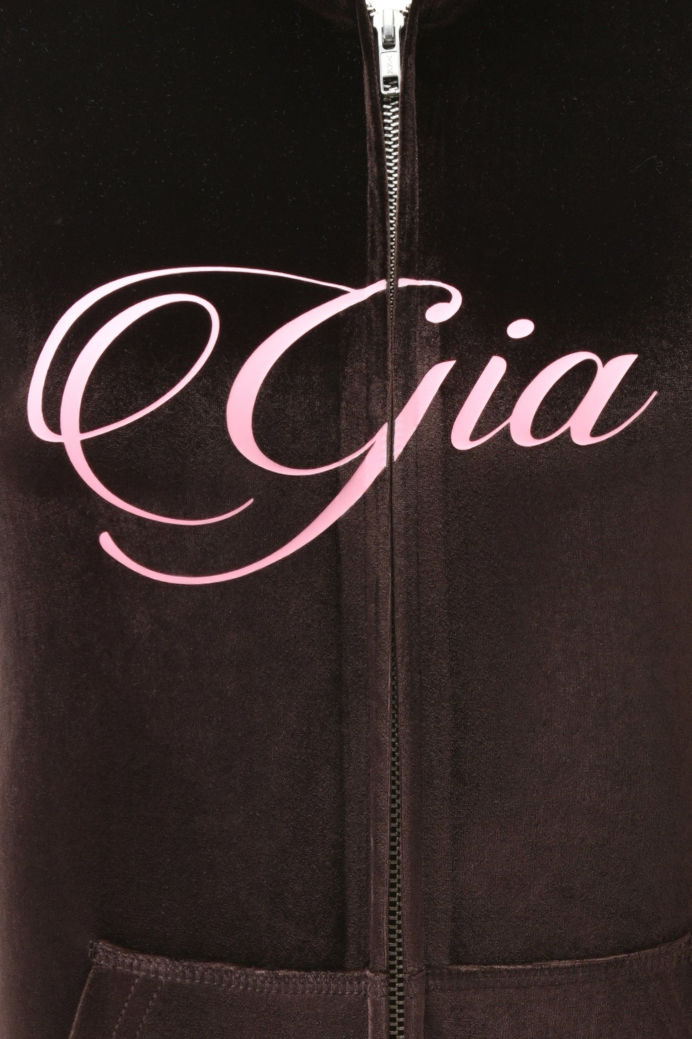 Close-up of the I.AM.GIA BLARE VELOUR POCKET HOODIE in chocolate brown, featuring "Gia" in bold pink cursive on the chest and a partially visible front zipper.