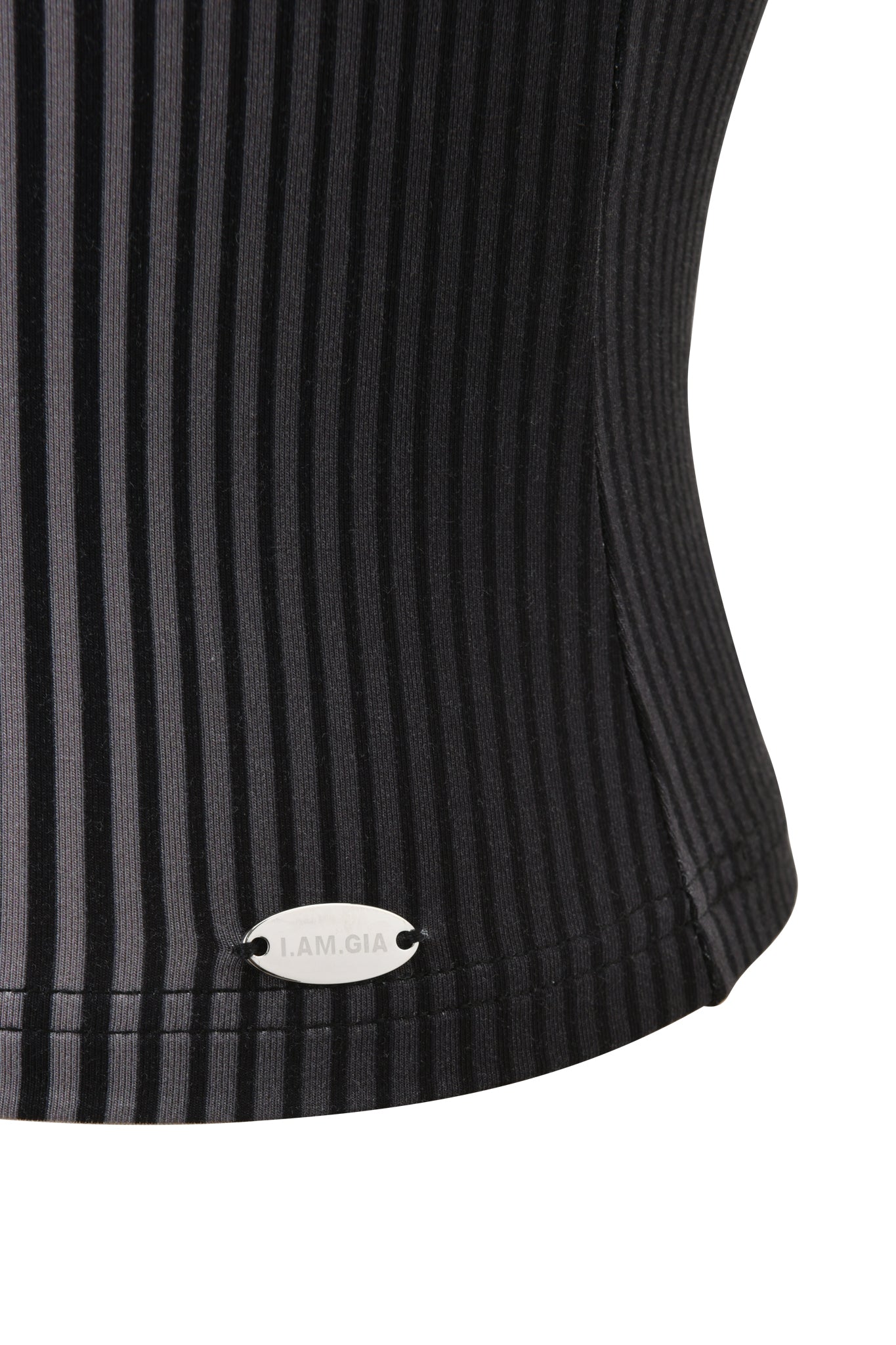 Close-up of the TRINITY BOOB TUBE - STRIPE by I.AM.GIA, a black ribbed strapless top with vertical stripes and a small oval "I.AM.GIA" metal tag near the hem.