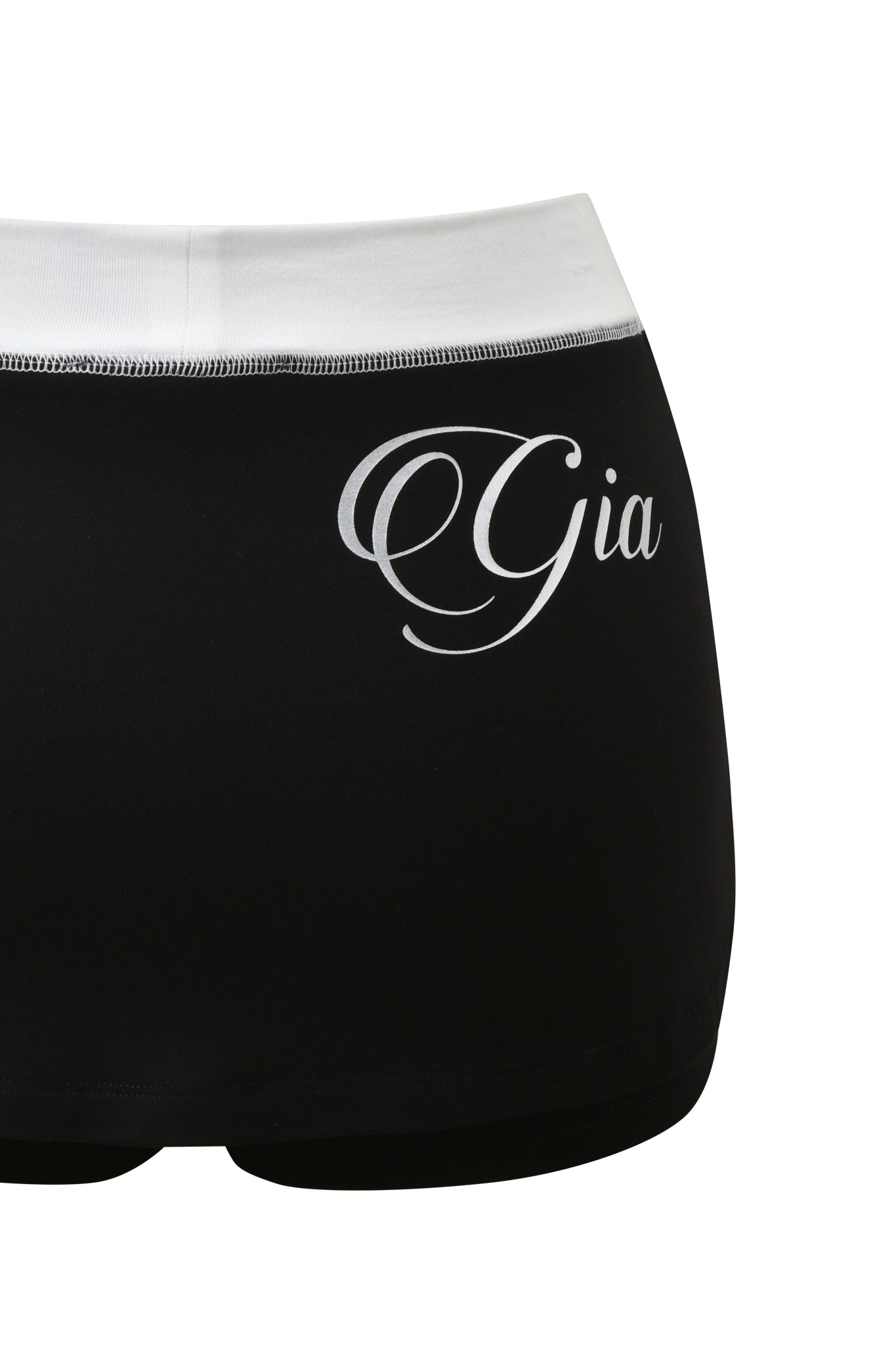 The BLARE MICRO SKORT by I.AM.GIA features a black and white design with the "Gia" name in elegant script on the front, crafted from ultra-soft viscose fabric for ultimate comfort.