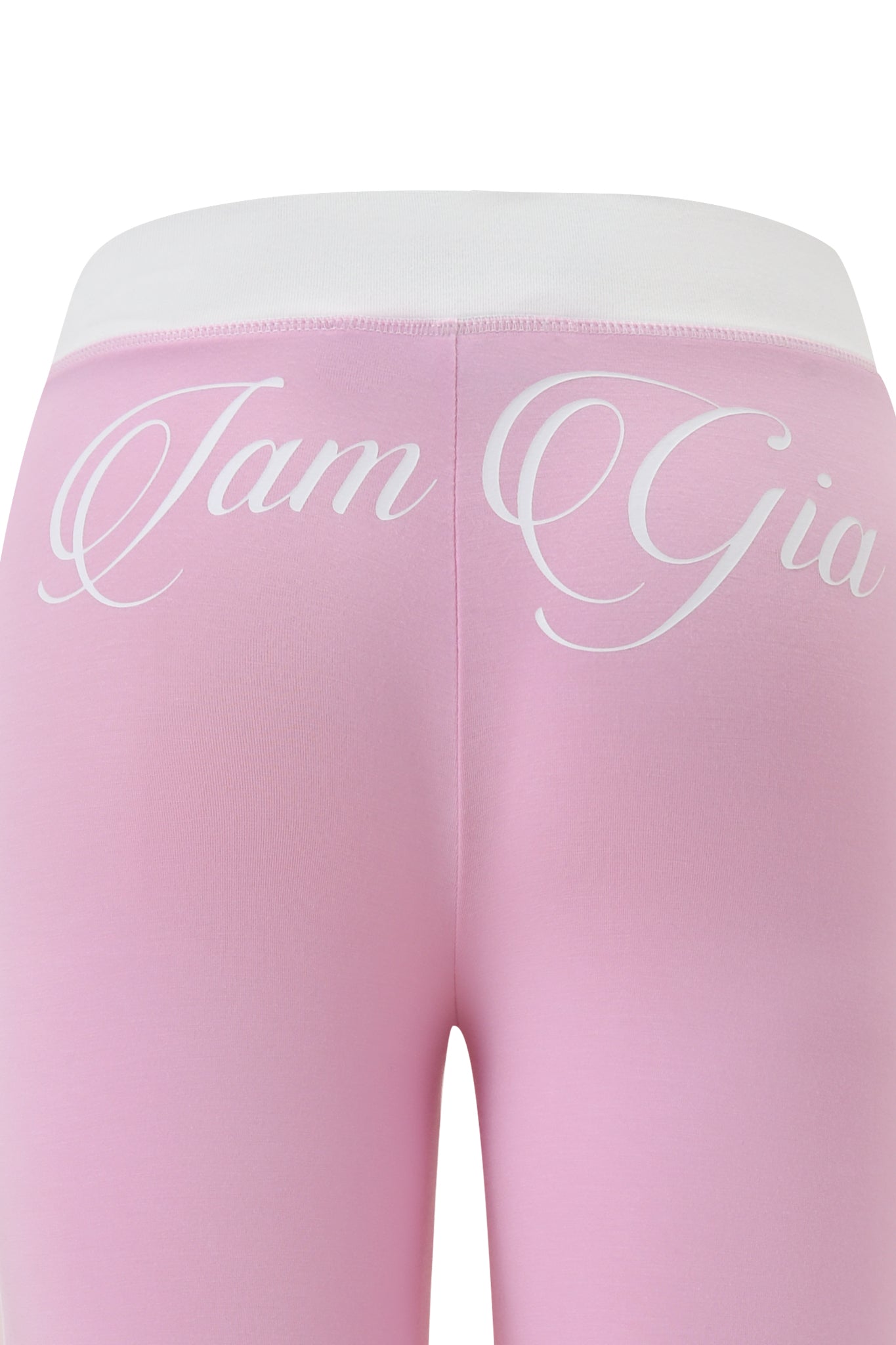 Close-up of the back of BLARE PIPING TRACKPANT in baby pink and white by I.AM.GIA, featuring a white waistband and "I.AM.GIA" in bold white script across the upper back.