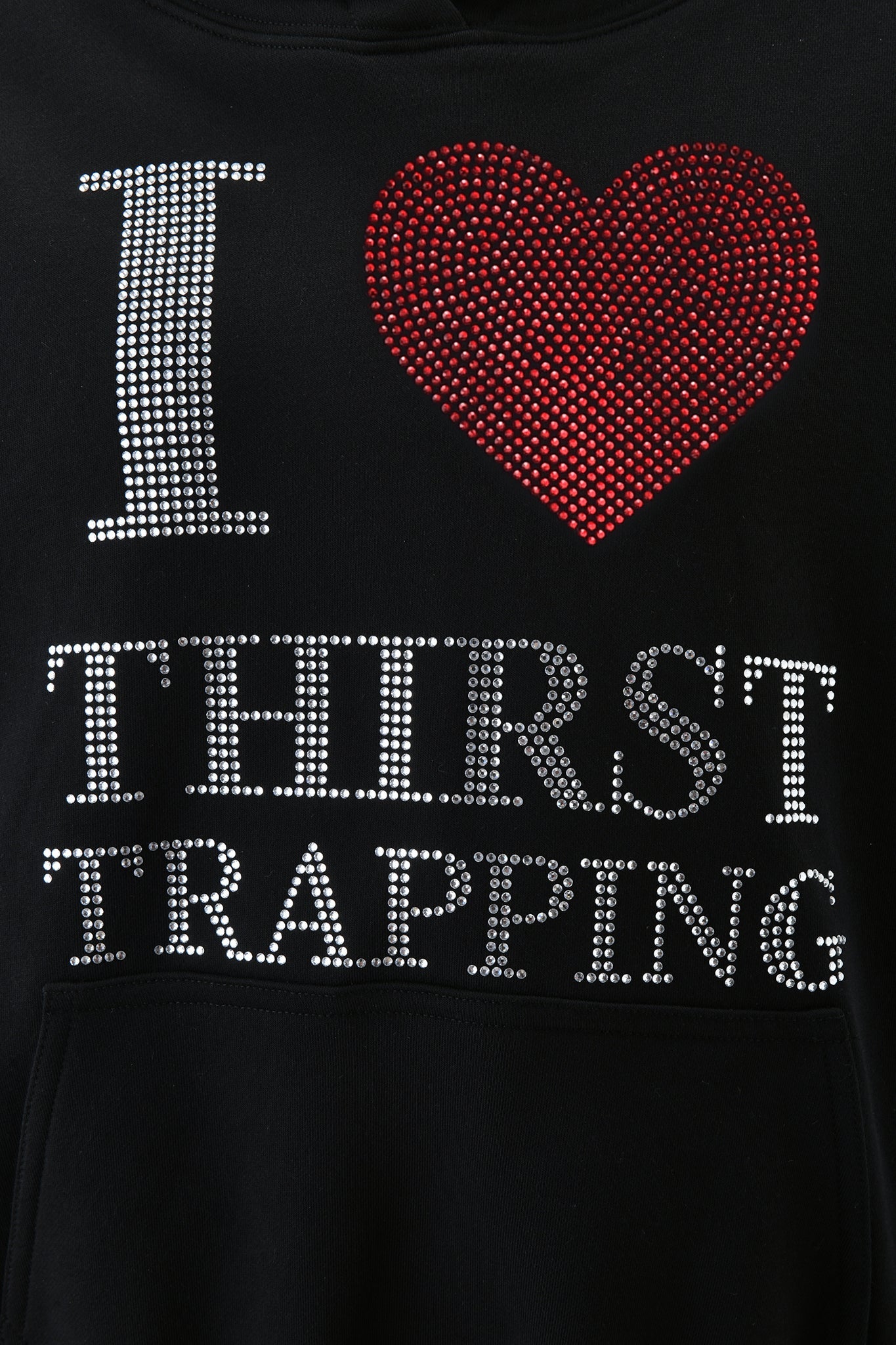 The POLINA HOODIE - THIRST TRAPPER by I.AM.GIA is a black hoodie with sparkling silver rhinestone text and a red rhinestone heart reading "I ♥ THIRST TRAPPING" for eye-catching style.