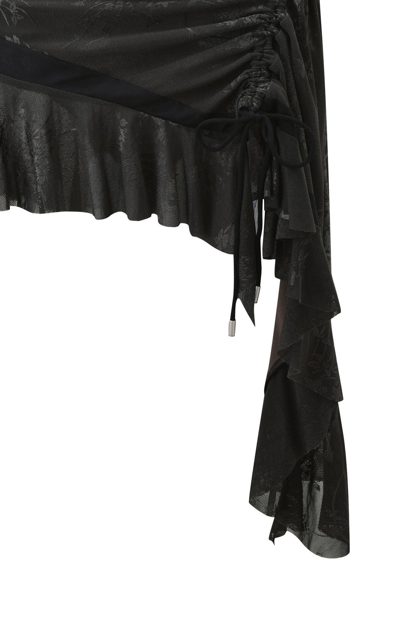 Close-up of the ISOLAE ASYMMETRICAL MINI SKIRT in black by I.AM.GIA, featuring semi-sheer black jacquard mesh, ruffled layers, ruched asymmetry, and a ribbon side tie for elegant draping.