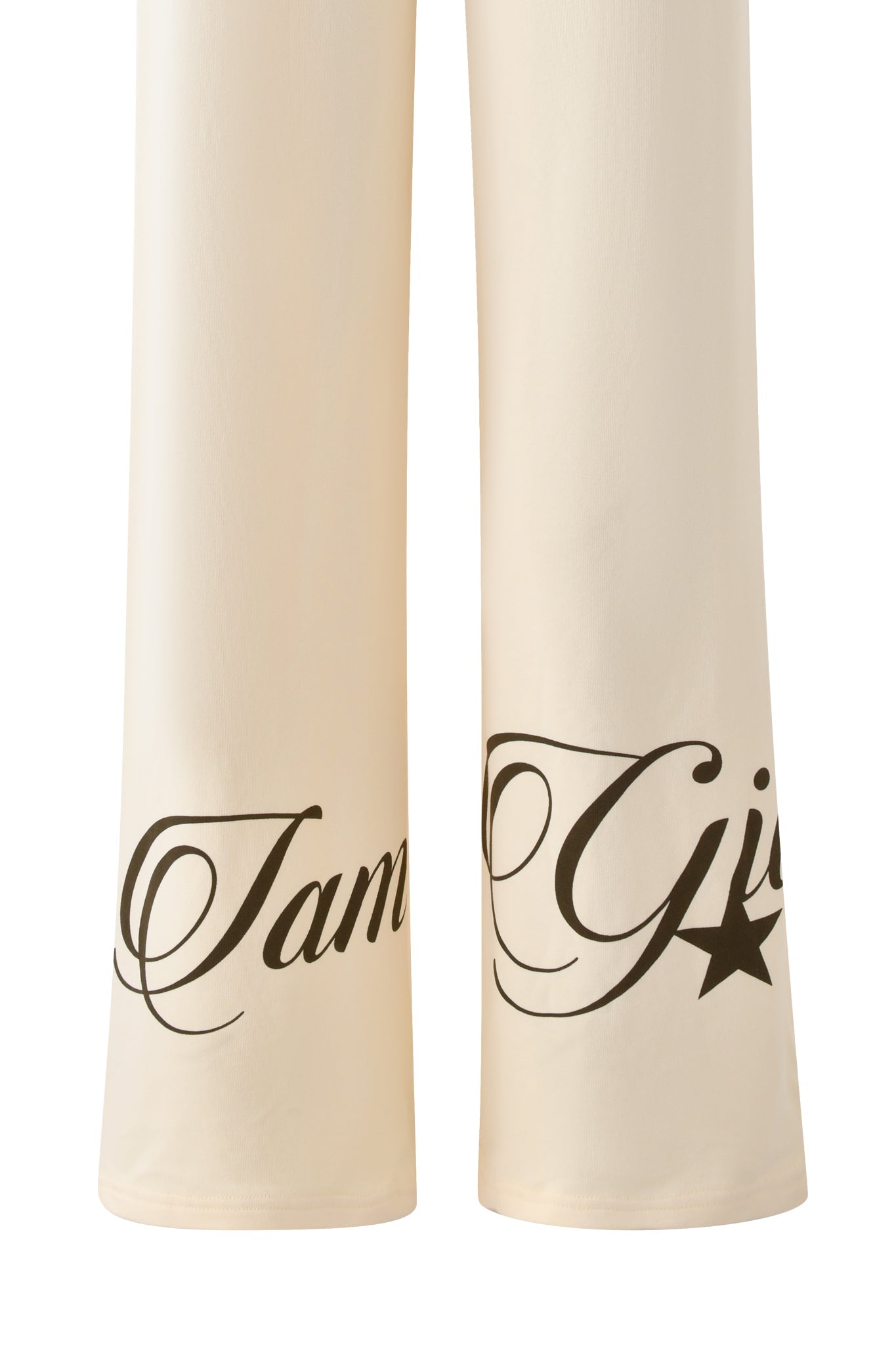 Close-up of the I.AM.GIA CANDI PANT in cream: wide-leg tracksuit pants with "Tam" and "Gis★" script near the hems, crafted from soft loopback terry fabric for comfort.