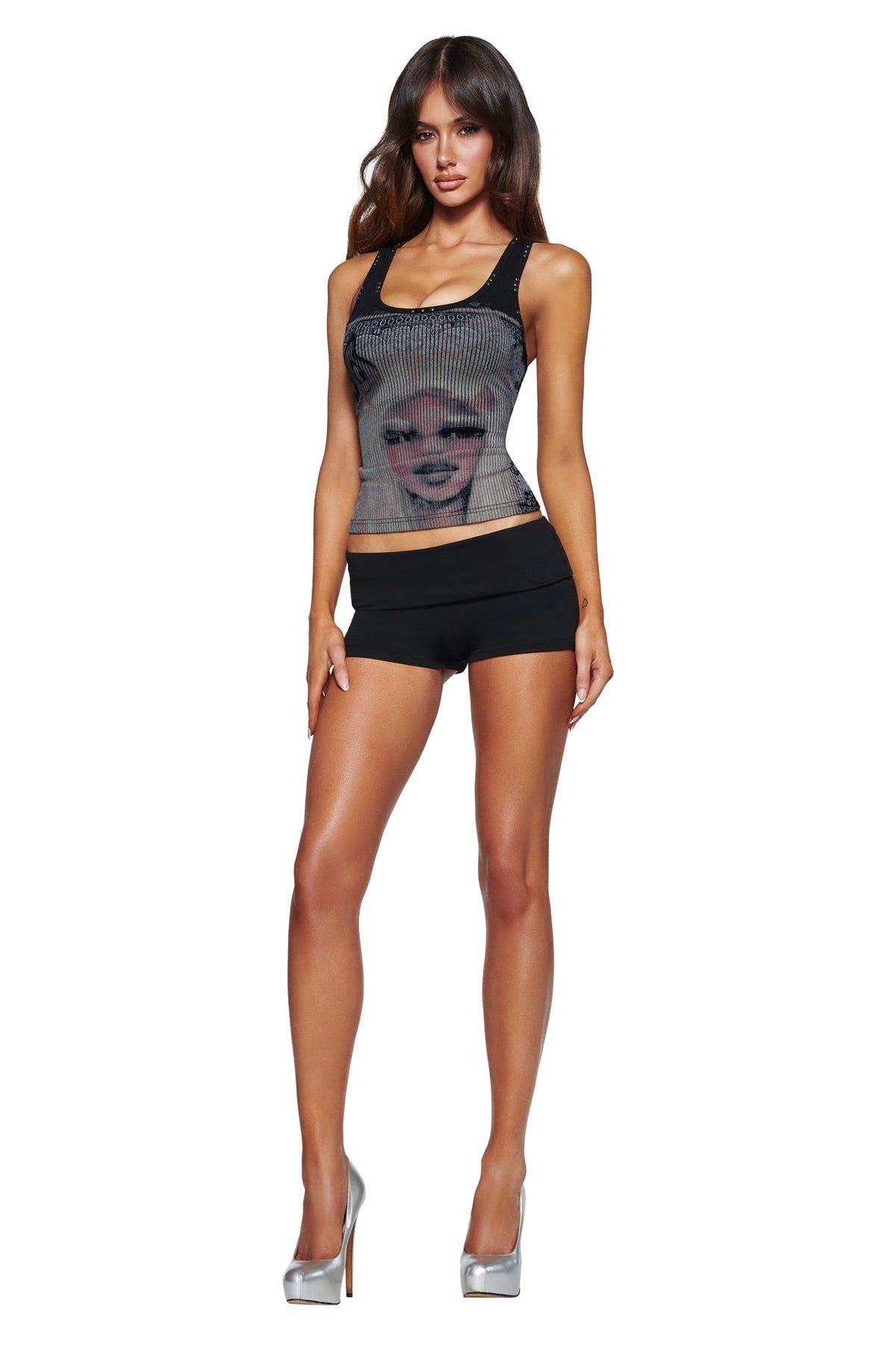 A woman wears the I.AM.GIA T-REX INA TANK - BLACK with black shorts and silver high heels, posing against a white background.