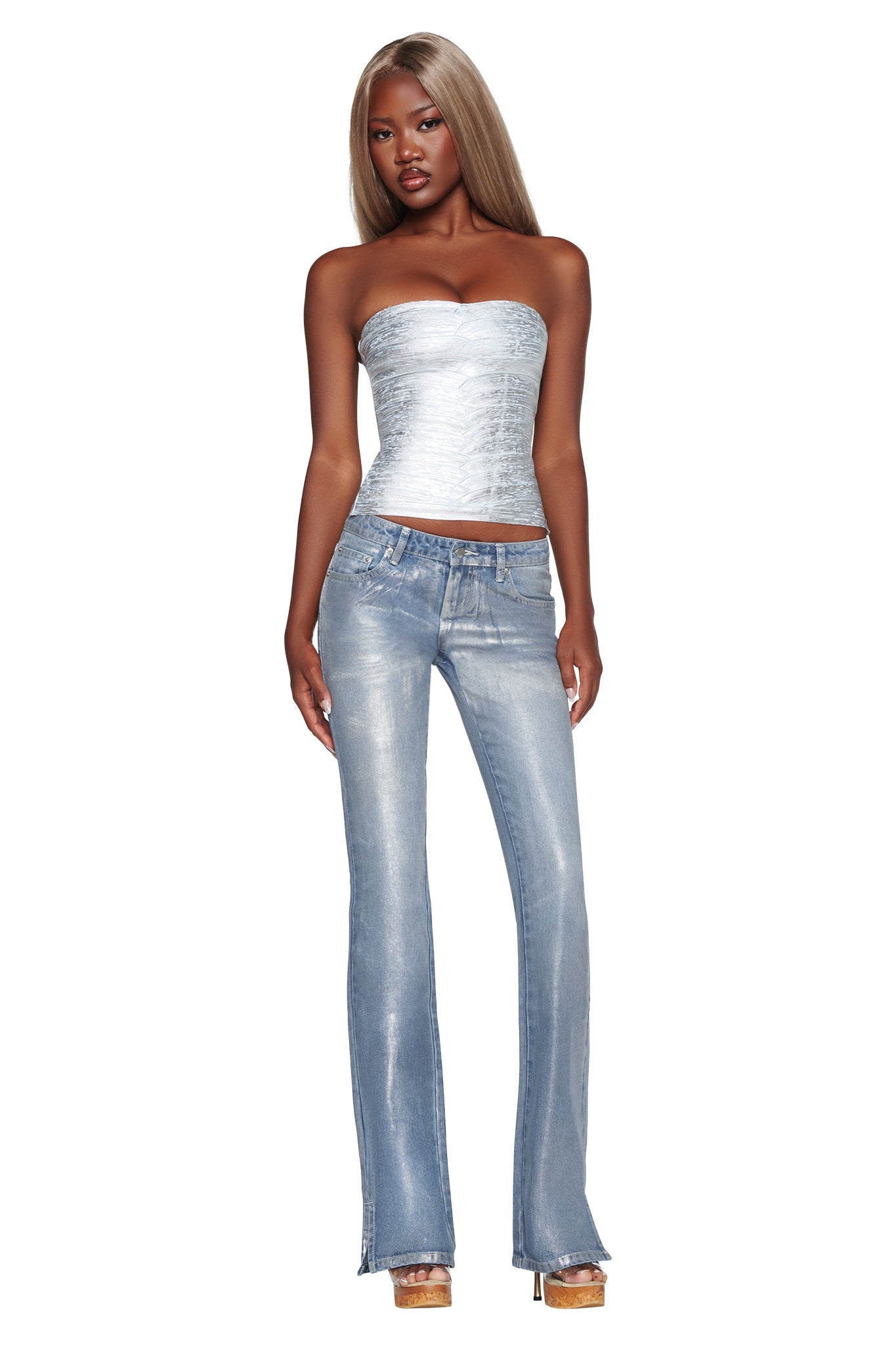 A woman with long blonde hair wears the I.AM.GIA KHIA BANDAGE BOOB TUBE in metallic blue, paired with light blue flared jeans that have a bodycon fit and platform heels. She stands facing forward against a white background.