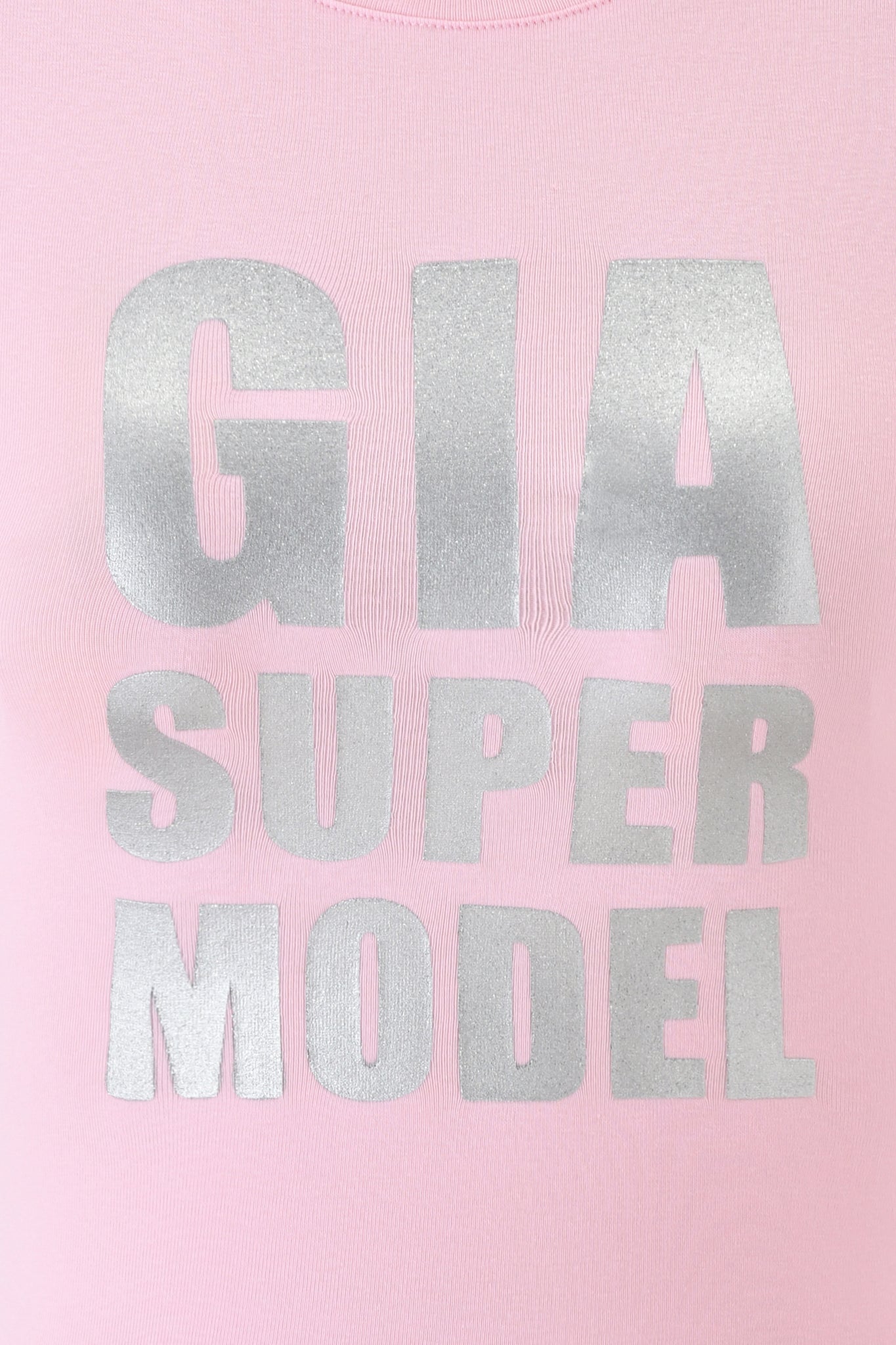 The COURTNEY TANK - SUPER MODEL by I.AM.GIA features a baby pink design with bold metallic glitter "SUPER MODEL" lettering across the front for a striking, bodycon fit.