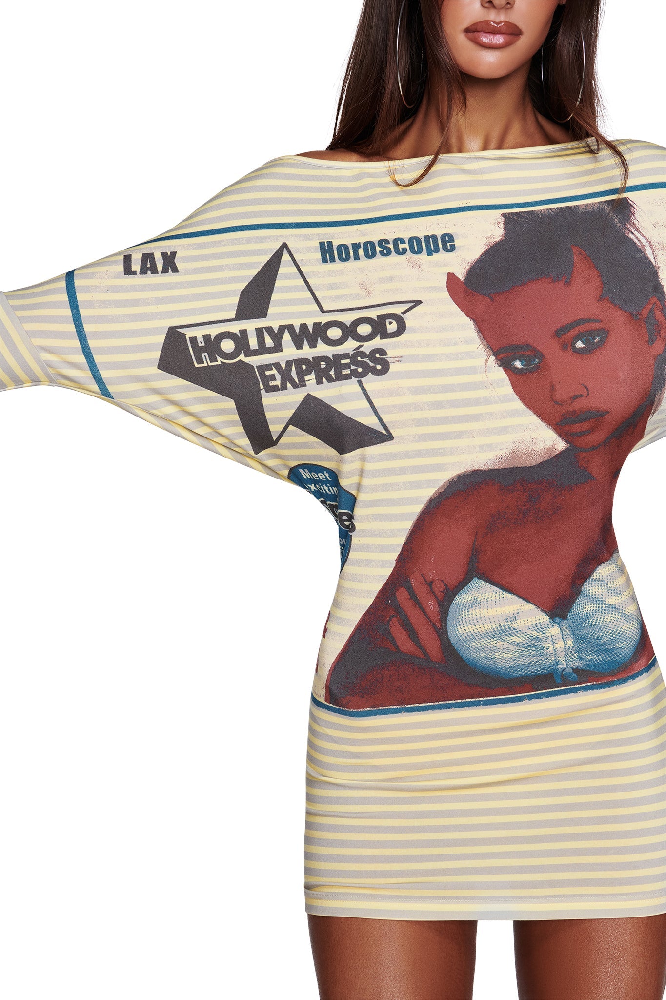 A woman is wearing the I.AM.GIA T-REX GISELLE OFF SHOULDER MINI DRESS in yellow, styled off-shoulder with batwing sleeves and yellow stripes. The dress features a bold graphic of a woman’s face, a star marked “Hollywood Express,” and striking text like “LAX” and “Horoscope.” Only one of her arms is fully visible.