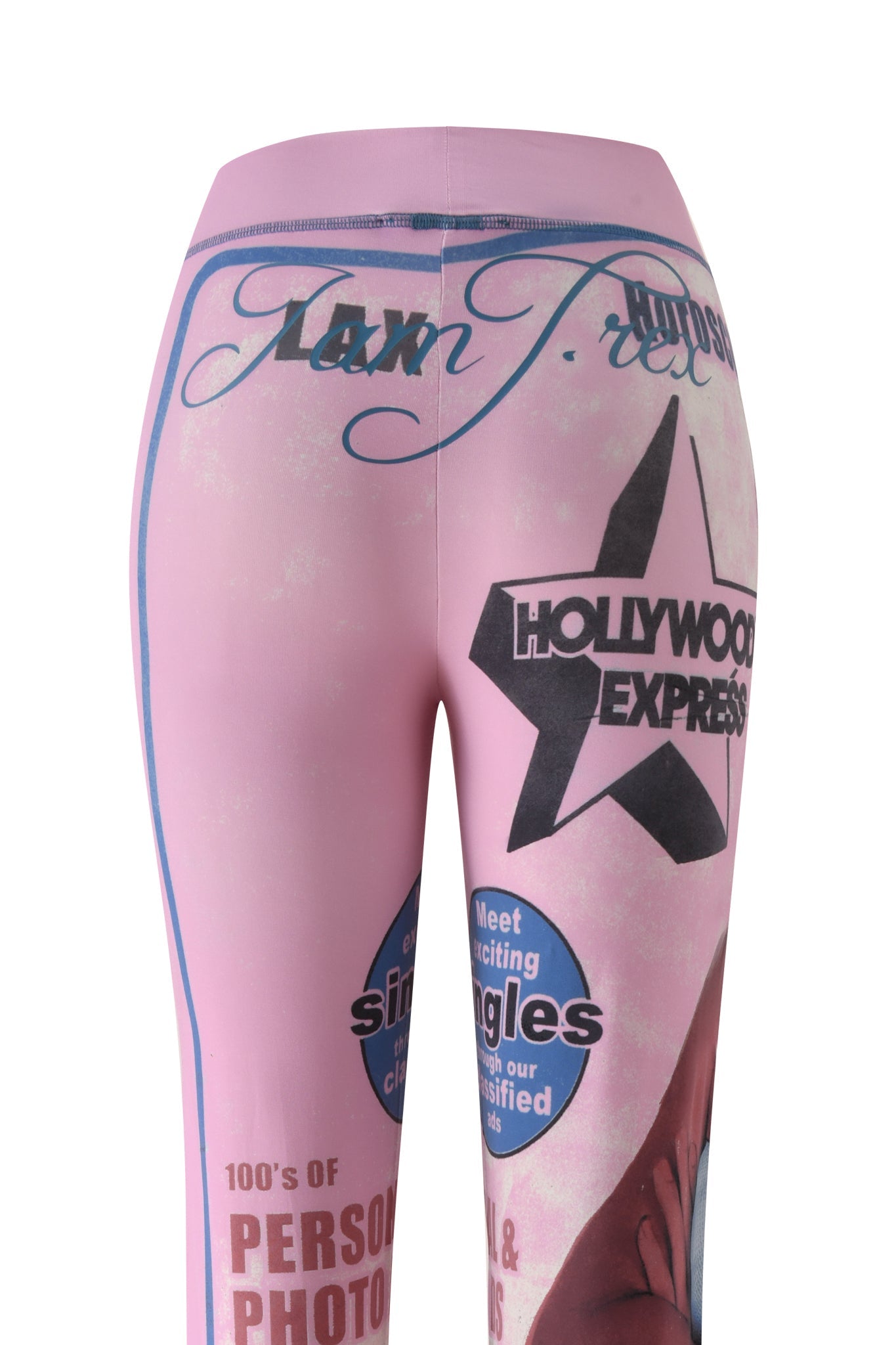 Introducing the I.AM.GIA T-REX BLARE TRACKPANT - PINK: These women’s lounge pants feature a striking pink base adorned with blue and black graphic text and imagery—including phrases like "Hollywood Express," a bold black star, and more. With their vibrant, vintage magazine cover-inspired design, these trackpants capture the playful spirit of T-REX style, making them the perfect statement piece to elevate your Blare Trackpant collection.