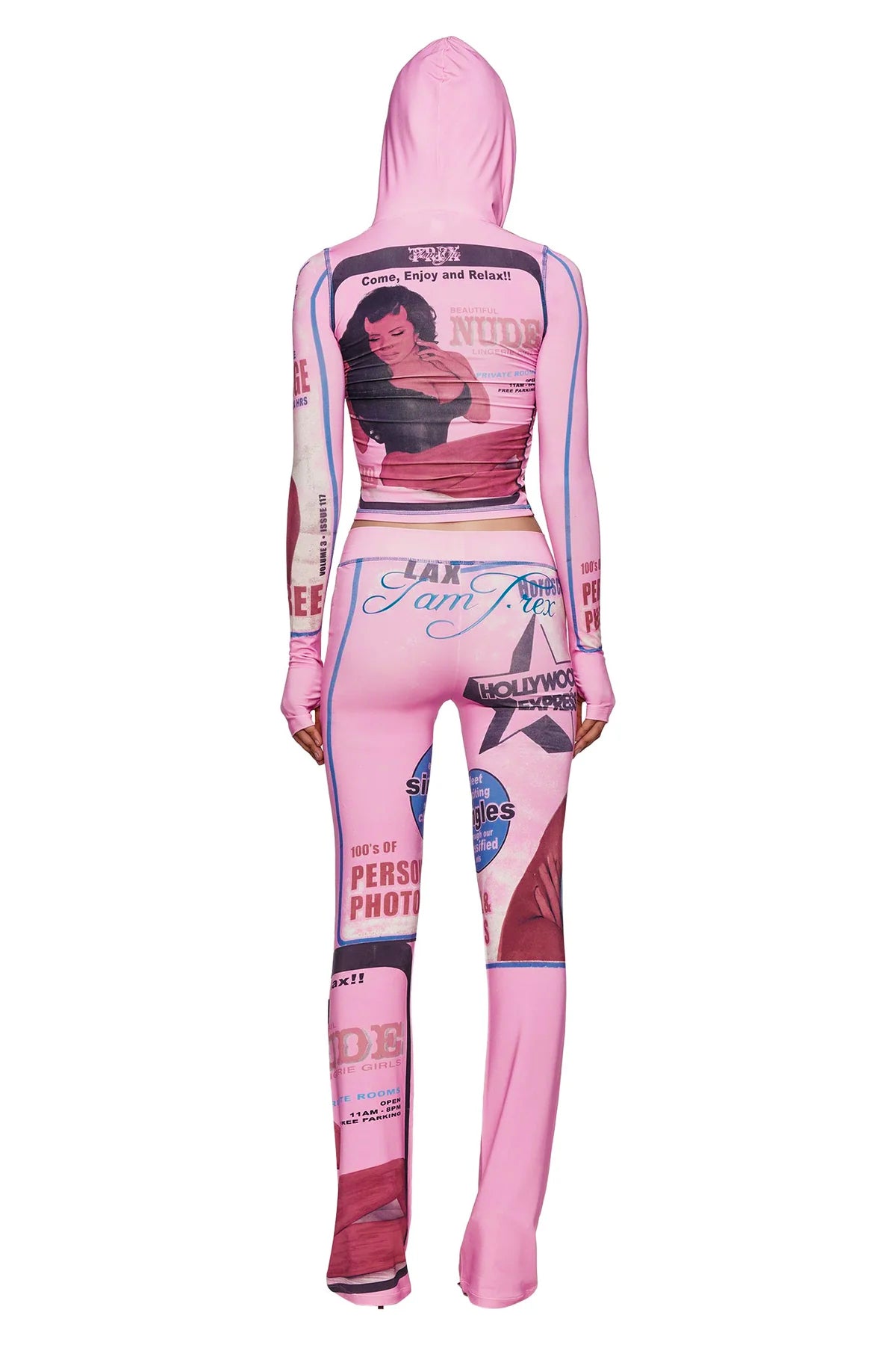 A person is seen from the back wearing the I.AM.GIA T-REX BLARE TRACKPANT in pink, featuring vintage-inspired print graphics and retro text in shades of pink, blue, and red—including a bold T-REX motif. The track pants channel an effortlessly cool vibe with their signature I.AM.GIA style.