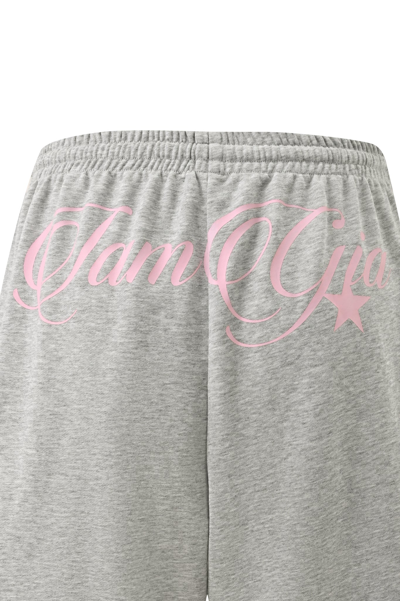 The BEX TERRY SHORT - GREY by I.AM.GIA are gray marle jersey shorts with a relaxed fit and an elasticated waistband, featuring pink cursive “I.AM.GIA” text and a star printed across the back waistband.