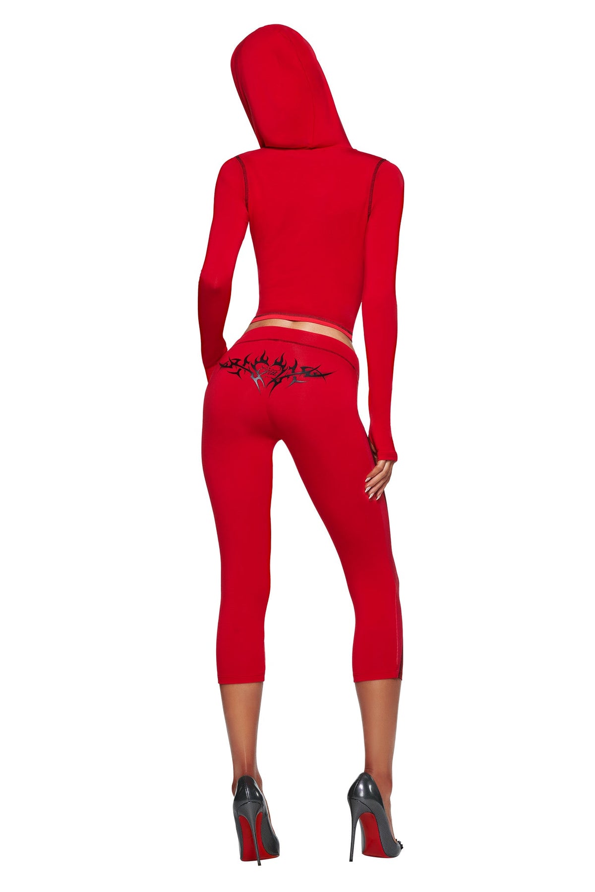 Woman wearing the T-REX SPRAY BODY BLARE HOODIE - RED by I.AM.GIA and matching red leggings with black design, paired with black heels, shown from behind on a white background.