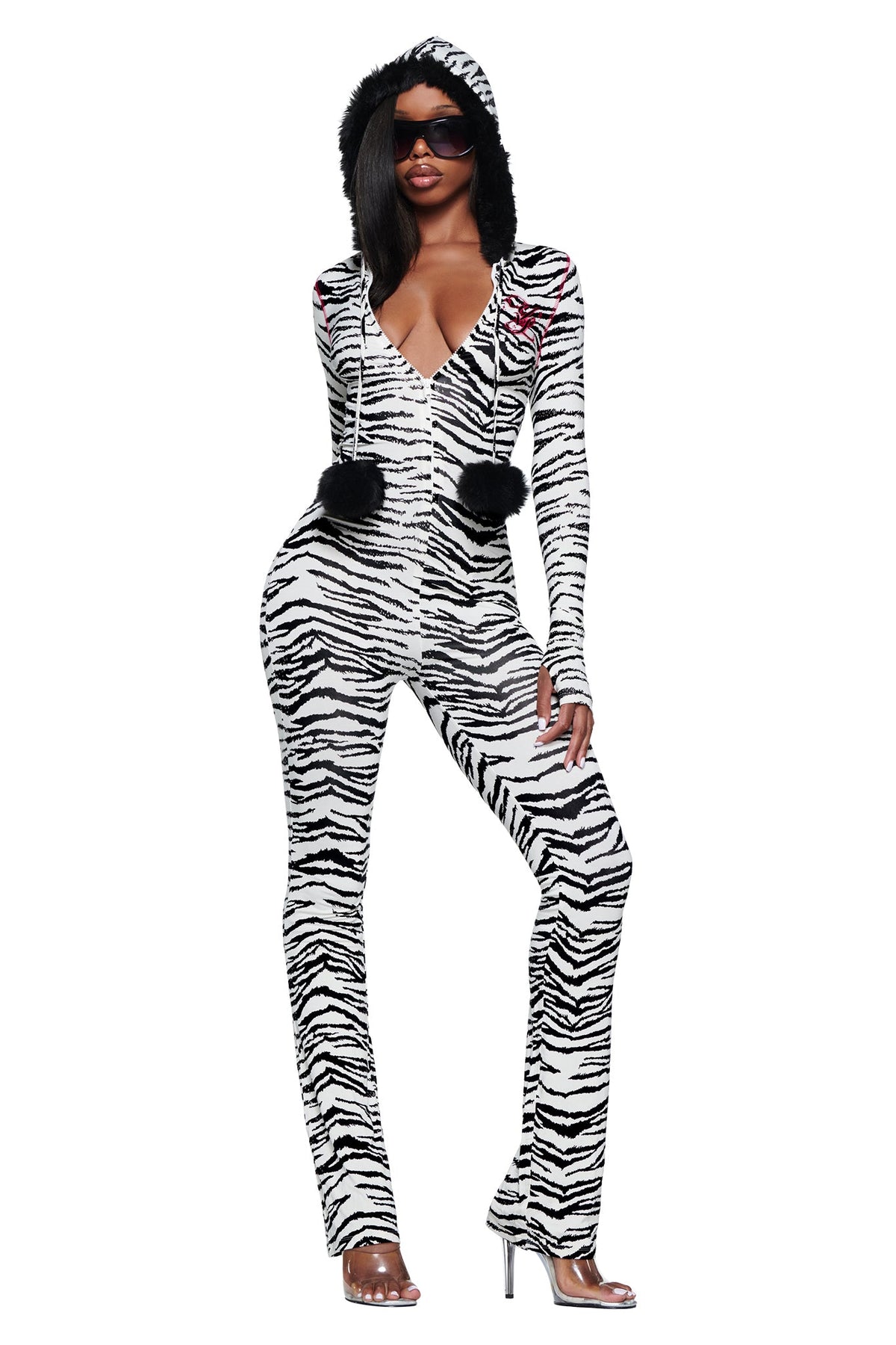 A person wearing a long-sleeved YVL BLARE FUR LINED JUMPSUIT - ZEBRA with a faux fur hood and dangling black pom-poms.