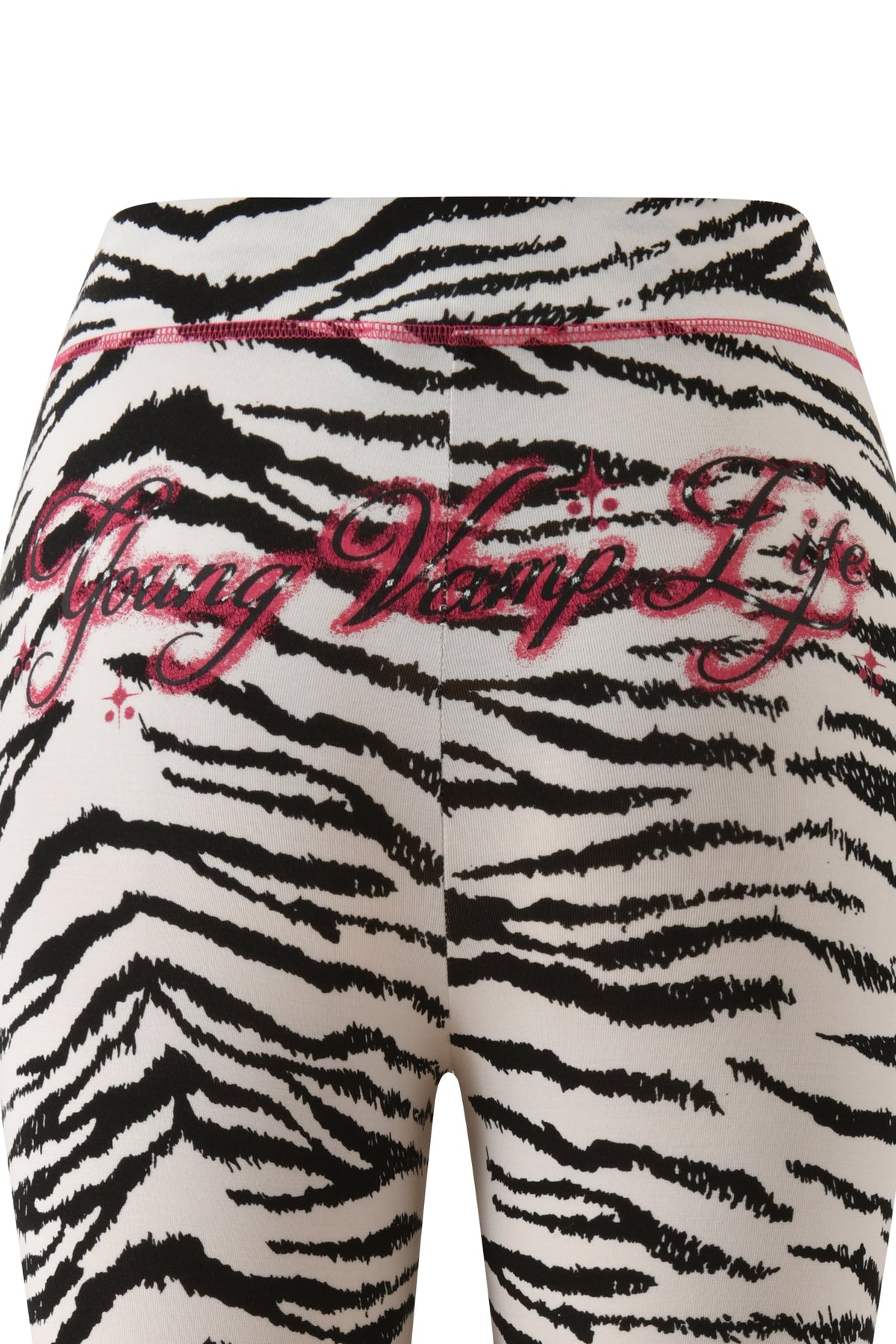 Close-up of I.AM.GIA YVL BLARE CAPRI - ZEBRA leggings featuring the text “Young Vamp Life” in pink glitter script across the back.