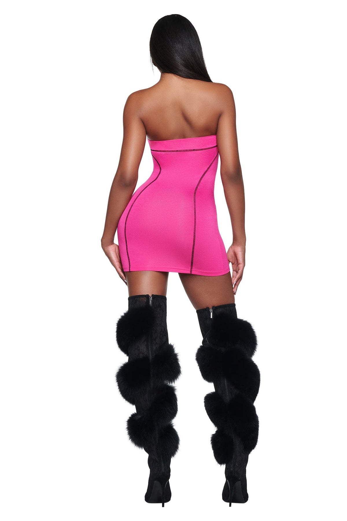A person seen from behind wearing a hot pink I.AM.GIA YVL BLARE TUBE MINI DRESS and black, fur-trimmed knee-high boots.