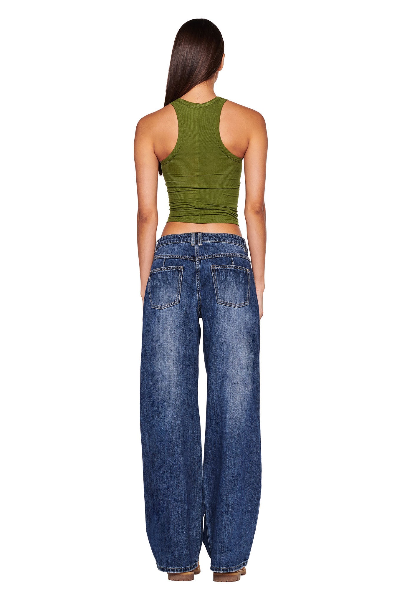 A person with long, straight hair is shown from the back, wearing a fitted green sleeveless top and the DYLAN JEAN - BLUE : DARK BLUE by I.AM.GIA. The individual is standing against a white background.