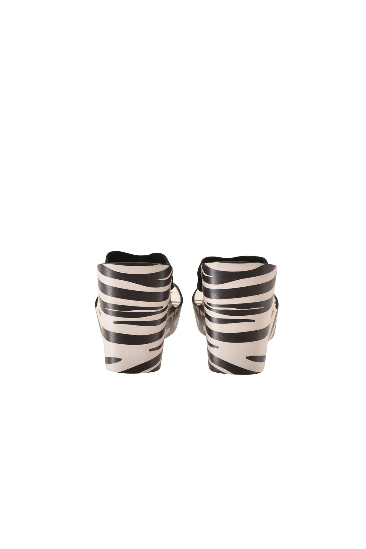 The SHELBY FLIP FLOP - FINE LINE ZEBRA by I.AM.GIA, a pair of black and white zebra-striped casual thong platform wedge sandals, are shown standing upright with the back view on a plain white background.